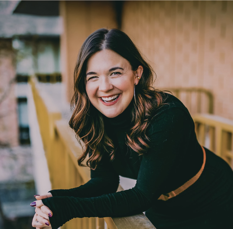Woman smiling and leaning against a balcony railing