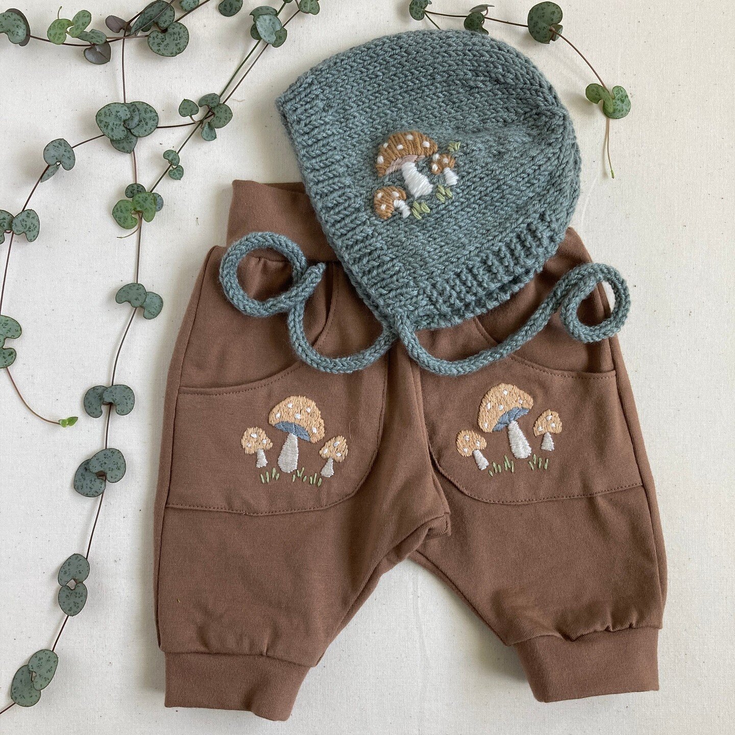 Toadstool embroidery on both a bonnet and handmade baby joggers. As I made the joggers myself, I embroidered the pockets first before I attached them, but it&rsquo;s also easy enough to embroider them on the pockets of store bought items. You could u
