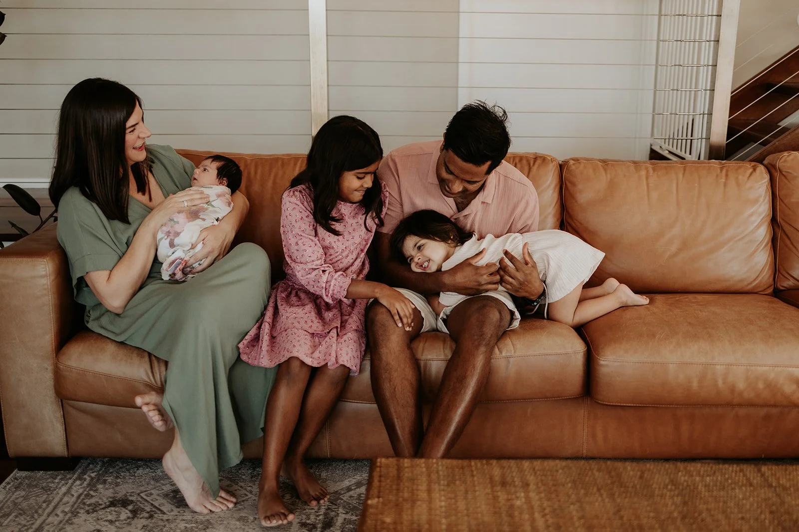A family welcoming their third baby is photographed in the relaxed comfort of their home. The colours of the outfits complement the environment and create beautiful artistry in the photo.