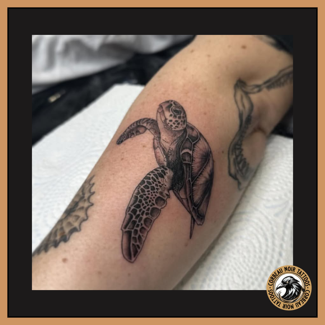 Tattoo of a sea turtle on a person's arm.
