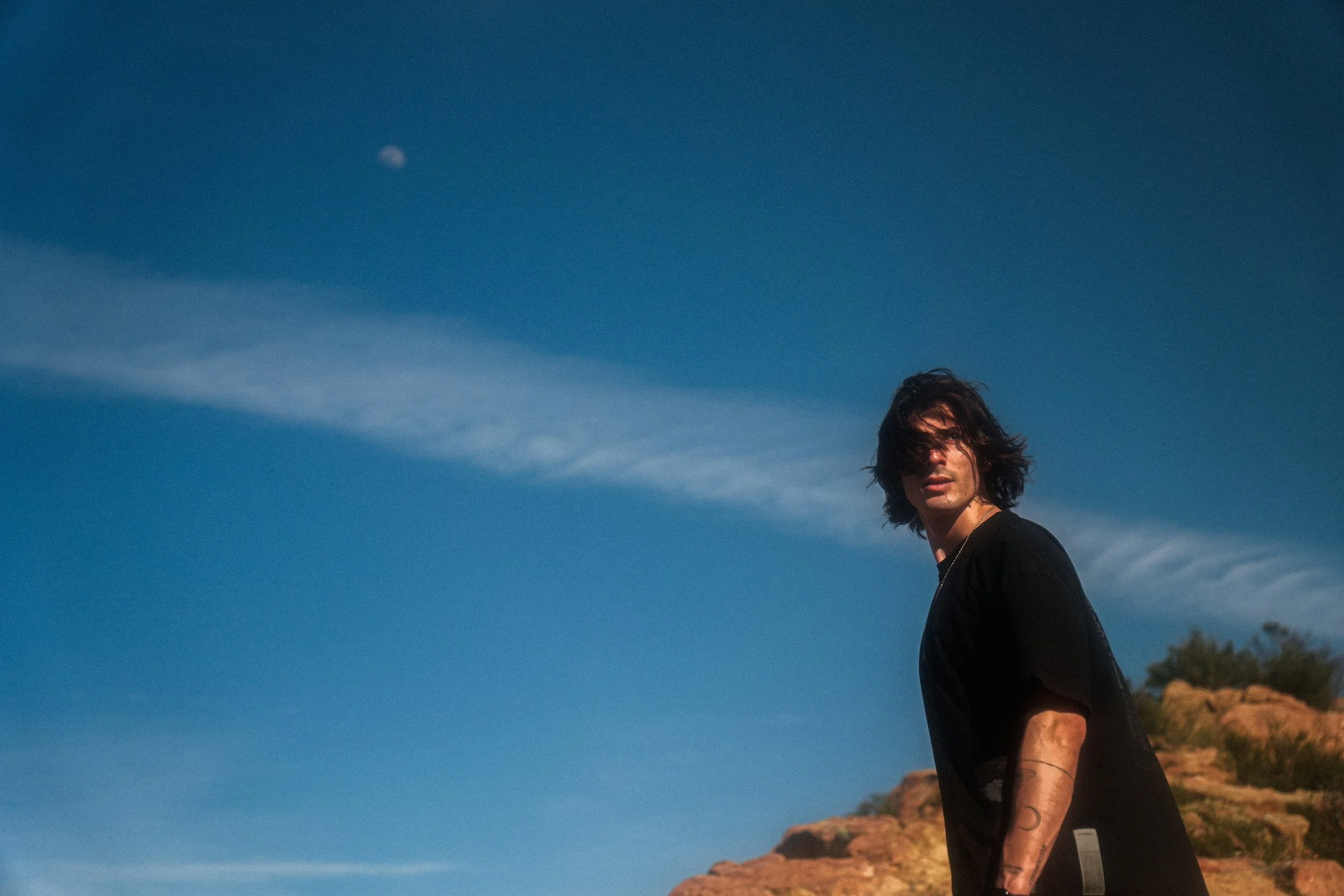 Ozz Gold standing beneath a blue sky