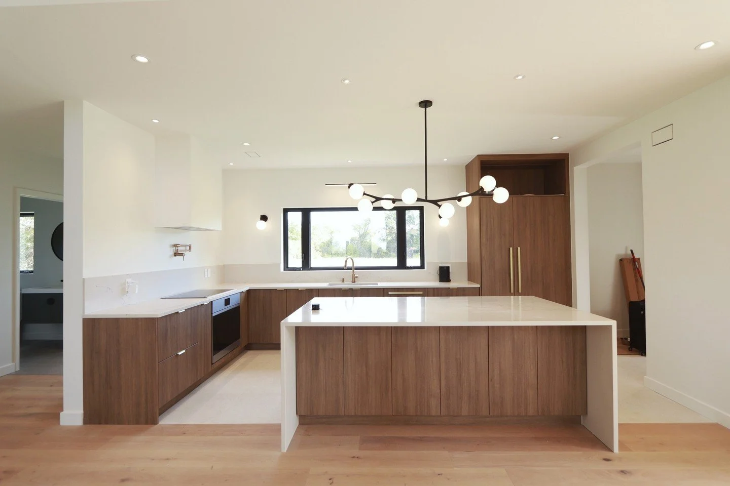 Light-filled mornings, seamless entertaining, and every detail thoughtfully designed. This modern wood kitchen blends style and function, from the panel-ready fridge to the open-concept flow into the living room. Our clients had a vision for this hom