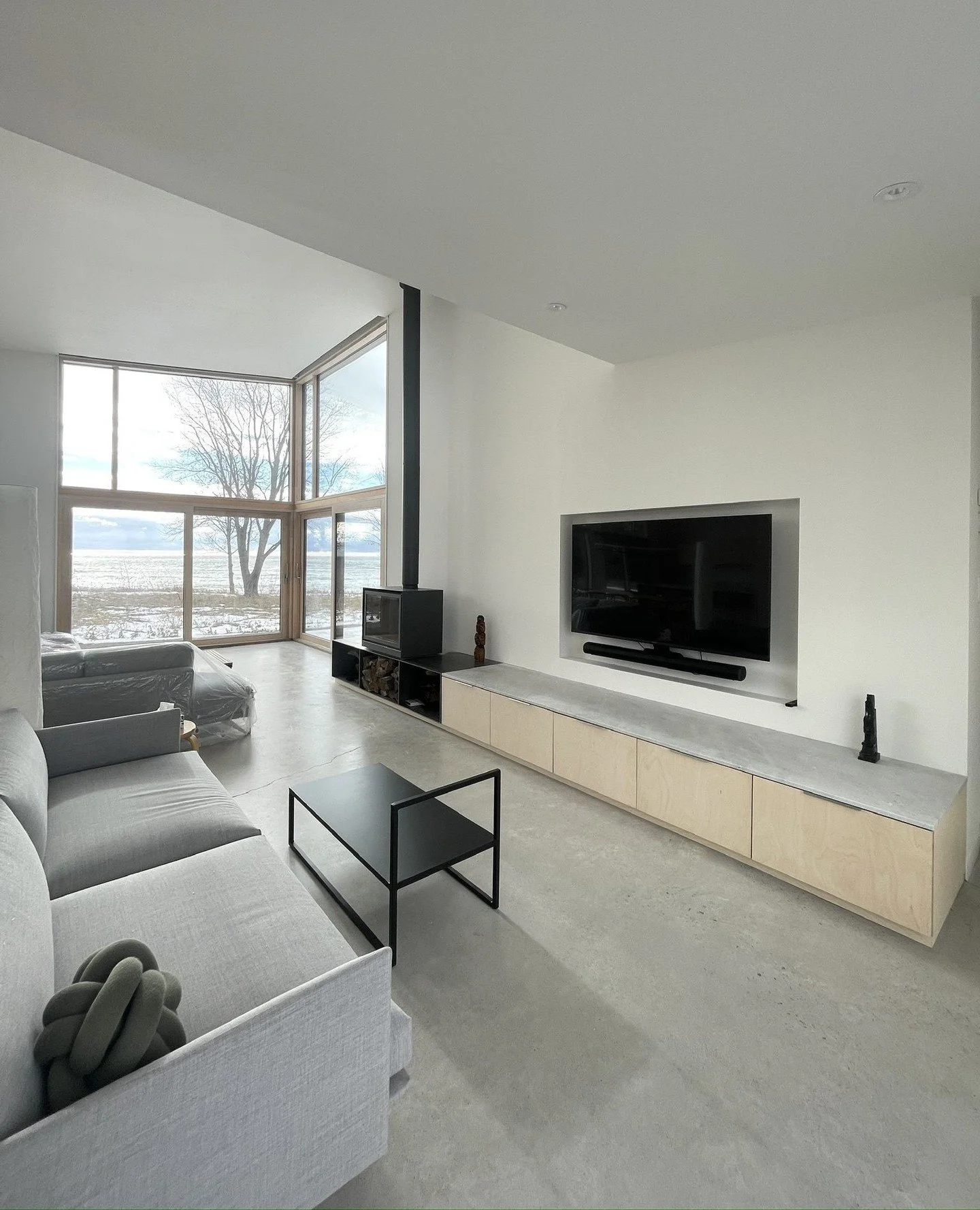 Step in and feel at home. This TV nook flows effortlessly into a spacious living area with built-in cabinets, a stunning woodstove, and floor-to-ceiling windows that frame serene lake views. Warmth, comfort, and luxury&mdash;all in one space. ✨ #Marq