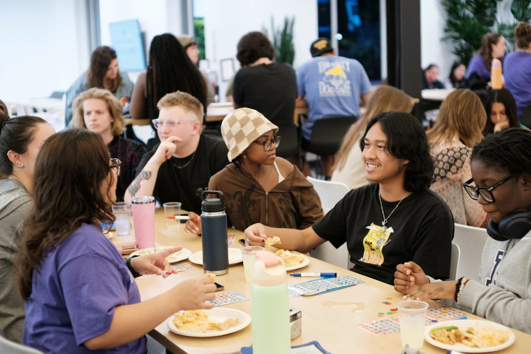 Chatham students in Anderson Dining Hall sit together eating and playing bingo