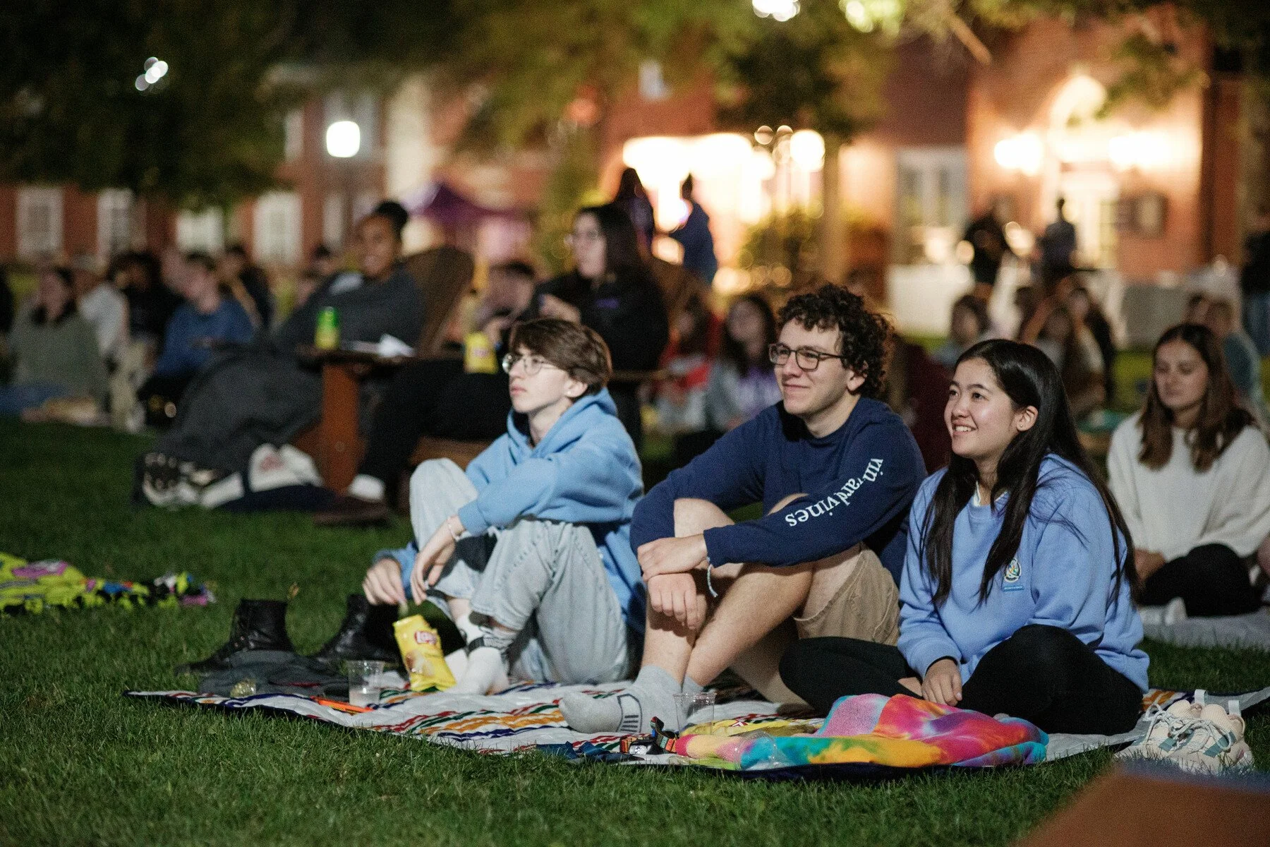 Students sit on blankets on the Quad during Orientation's Movie Night Under the Stars