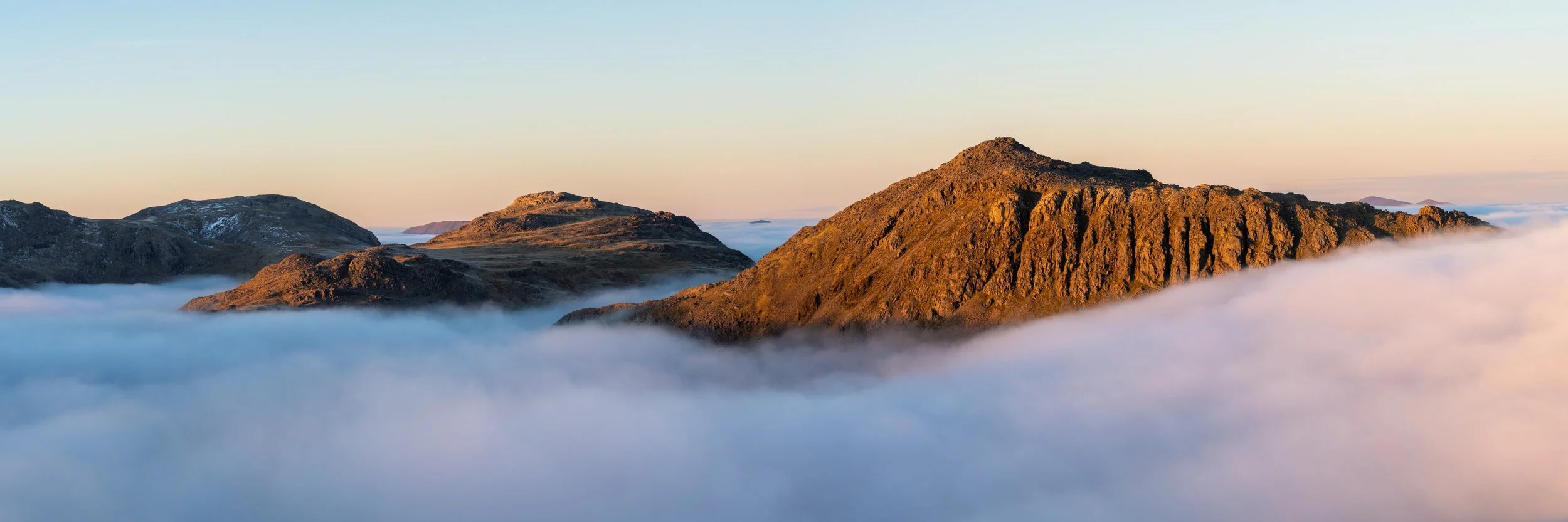 Bowfell at sunset above a cloud inversion in the fells of the Lake District, landscape photography.