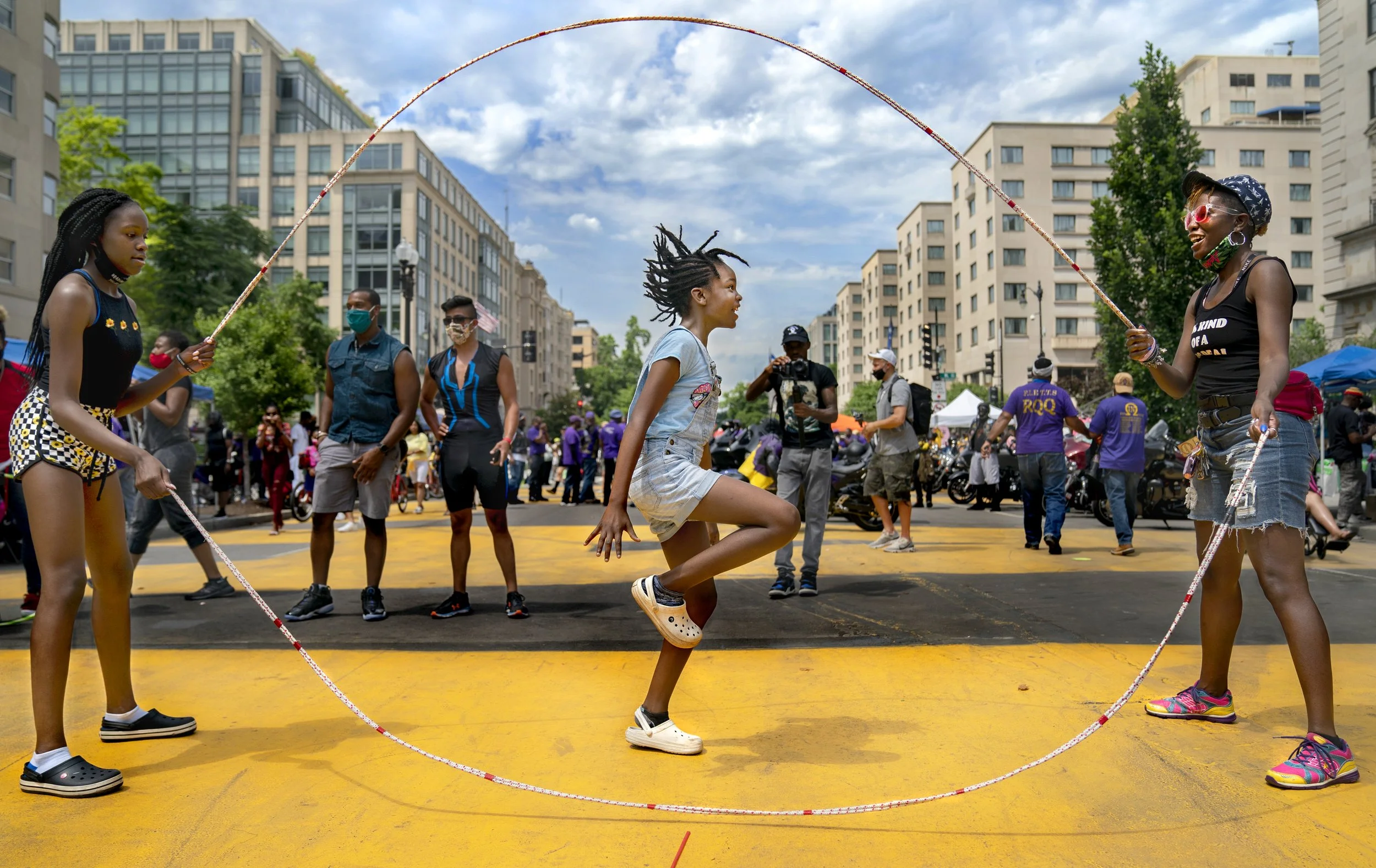 (photo by Evelyn Hockstein for The Washington Post) Washington, D.C., June 27, 2020: Taylor Blackwell, 9, jumps Double Dutch rope while her mom Danielle Blackwell and sister Jaelynn, 12, turn. Taylor and her sister are on the Greenbelt S.I.T.Y. Stars