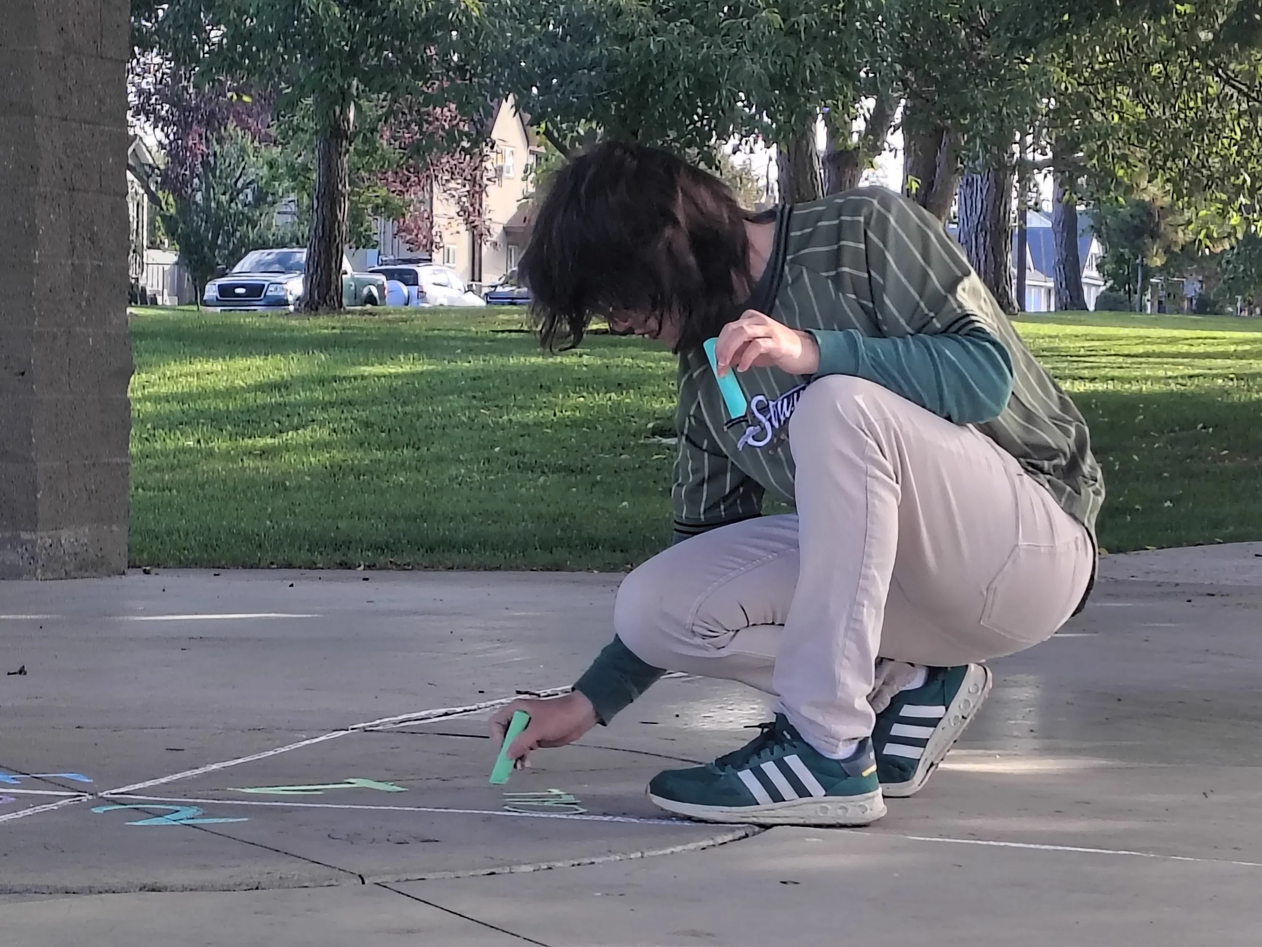 Colorful chalk sticks on a concrete surface with chalk drawings.