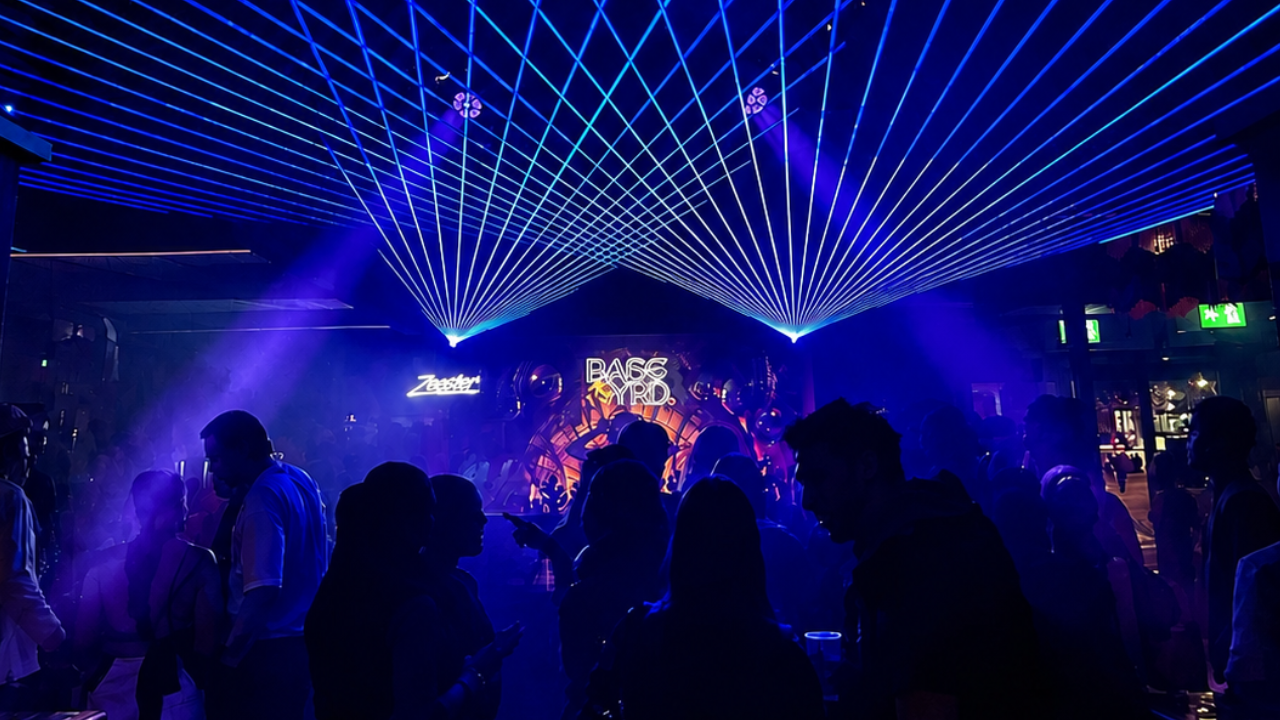 Lasers en licht effecten in een club waar gedanst wordt en muziek wordt gedraaid.