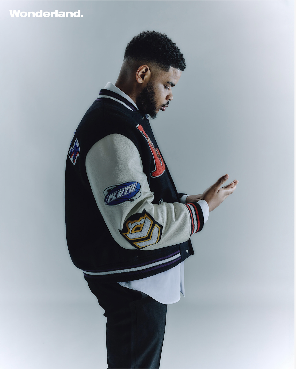 Wonderland magazine editorial portrait featuring K-Trap in studio wearing varsity jacket photographed by Radhika Muthanna