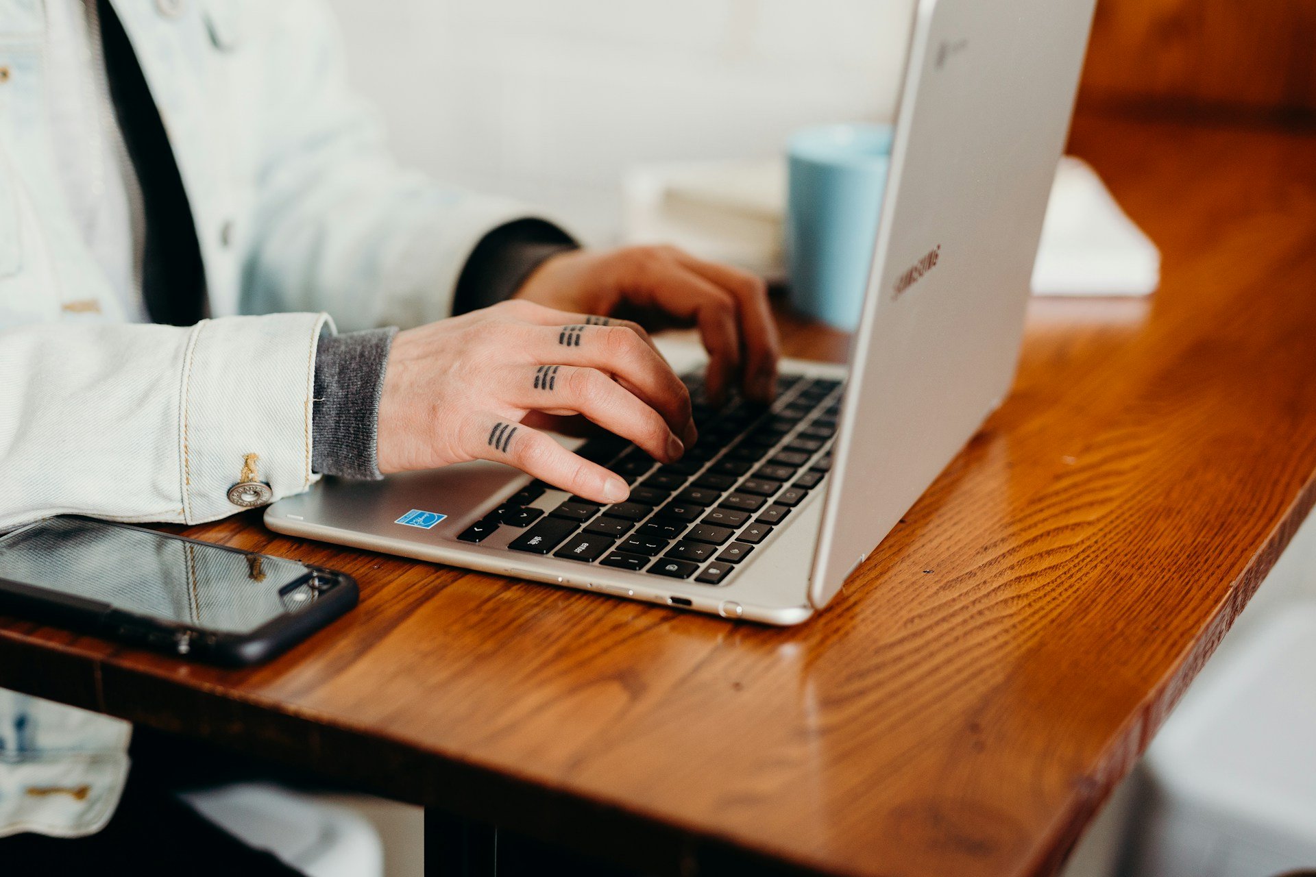 Person working on their laptop at a cafe trying to do everything at once as solopreneurs do.