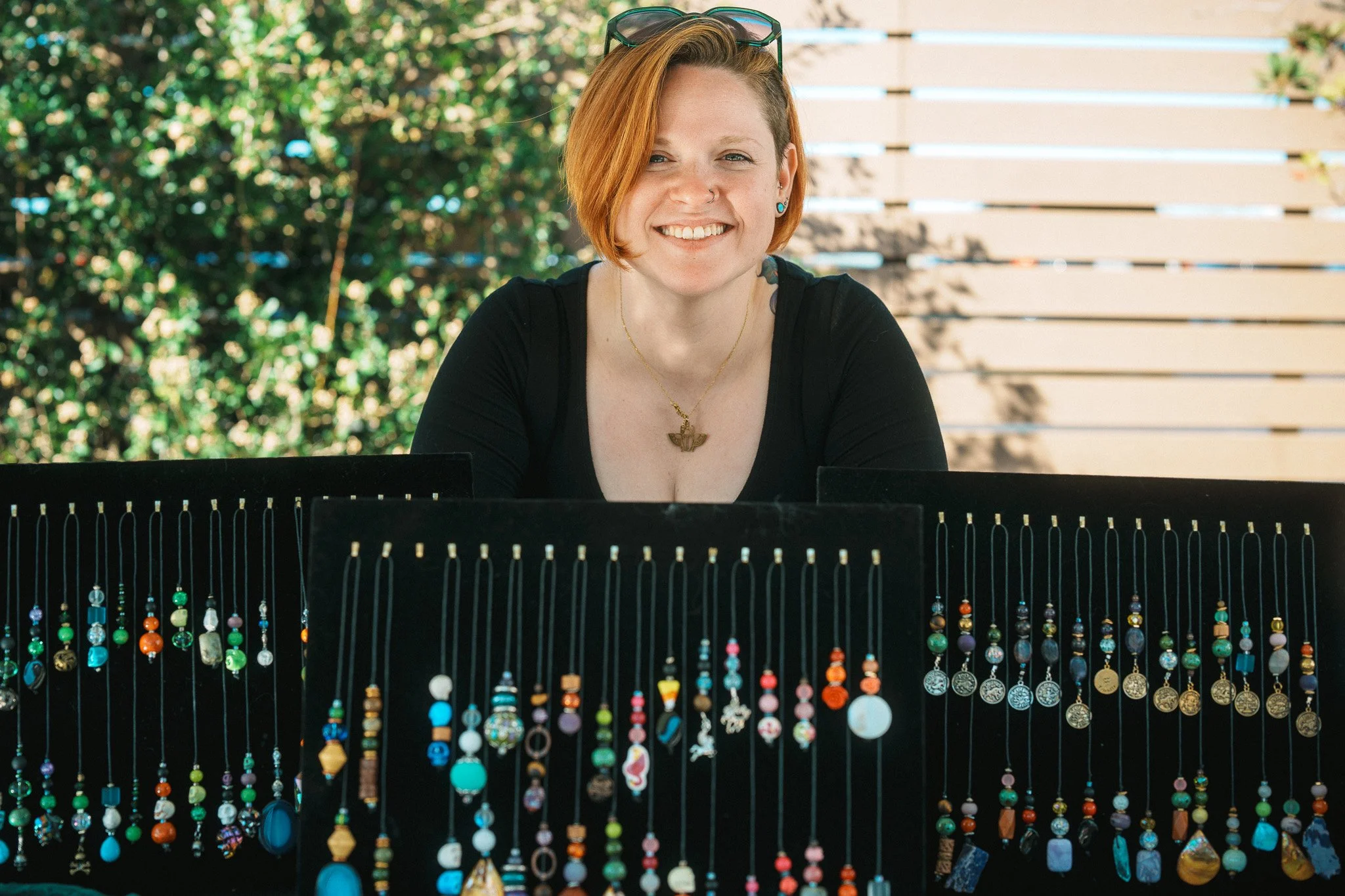 A local artist proudly standing by her jewelry collection on discplay