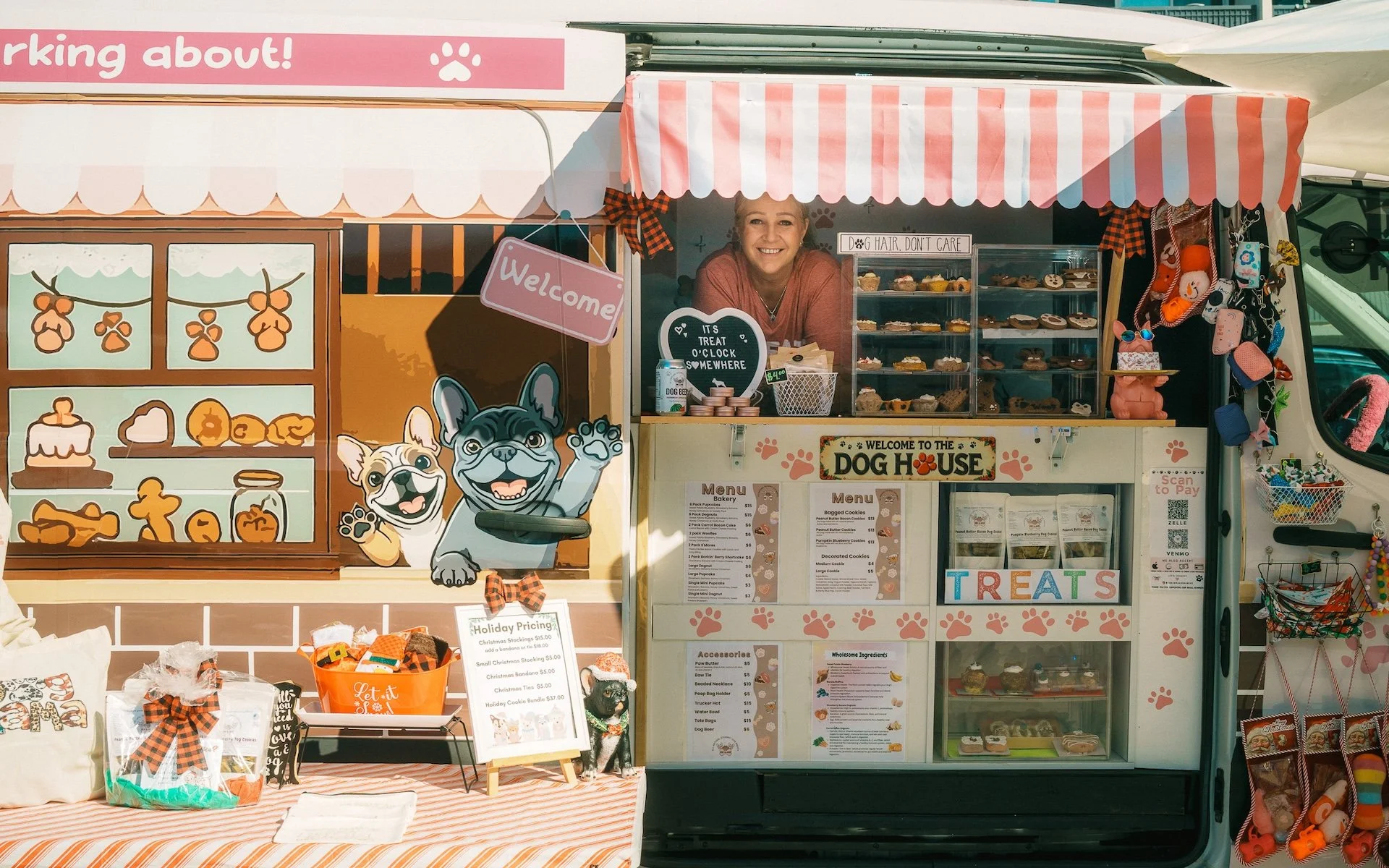 Local business owner standing by the window of her business with a huge smile on her face