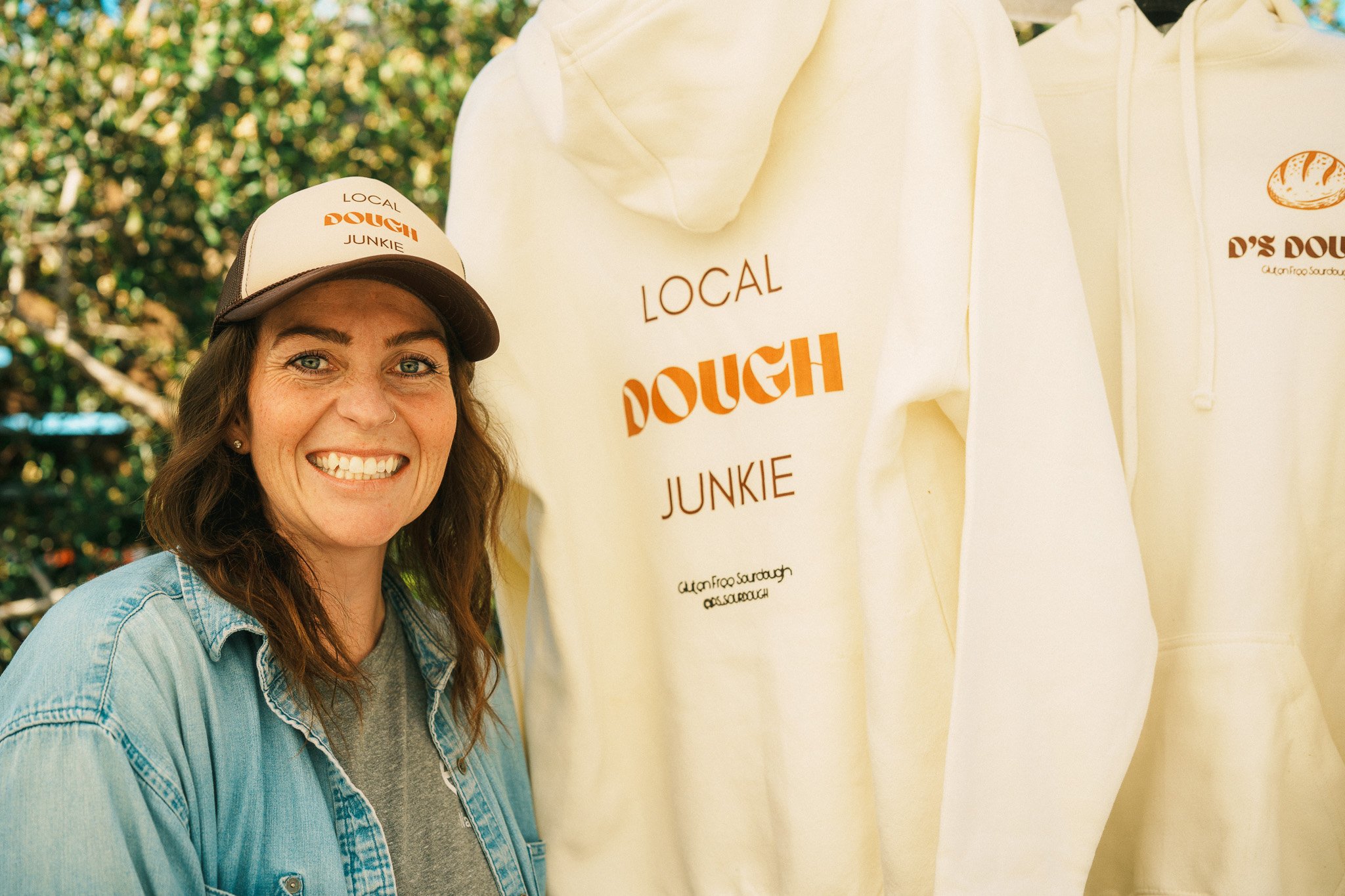A local business owner  proud of her business standing next to her merchandise