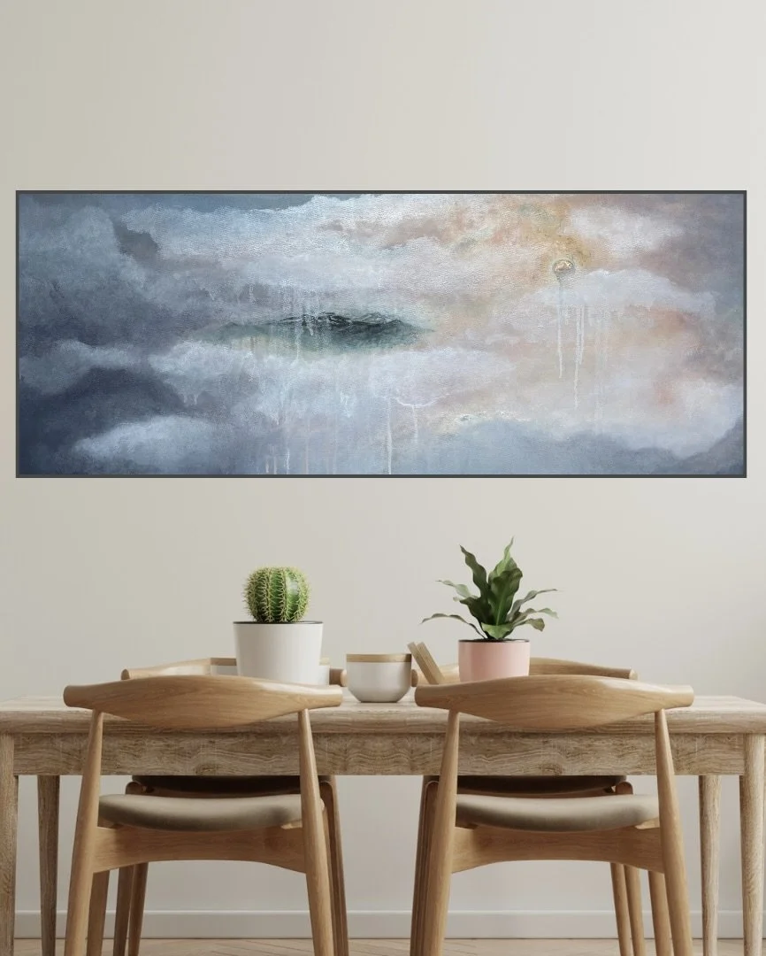 Interior scene with a wooden dining table and four chairs, decorated with a cactus and a leafy plant in white and pink pots, hanging abstract landscape painting on the wall.