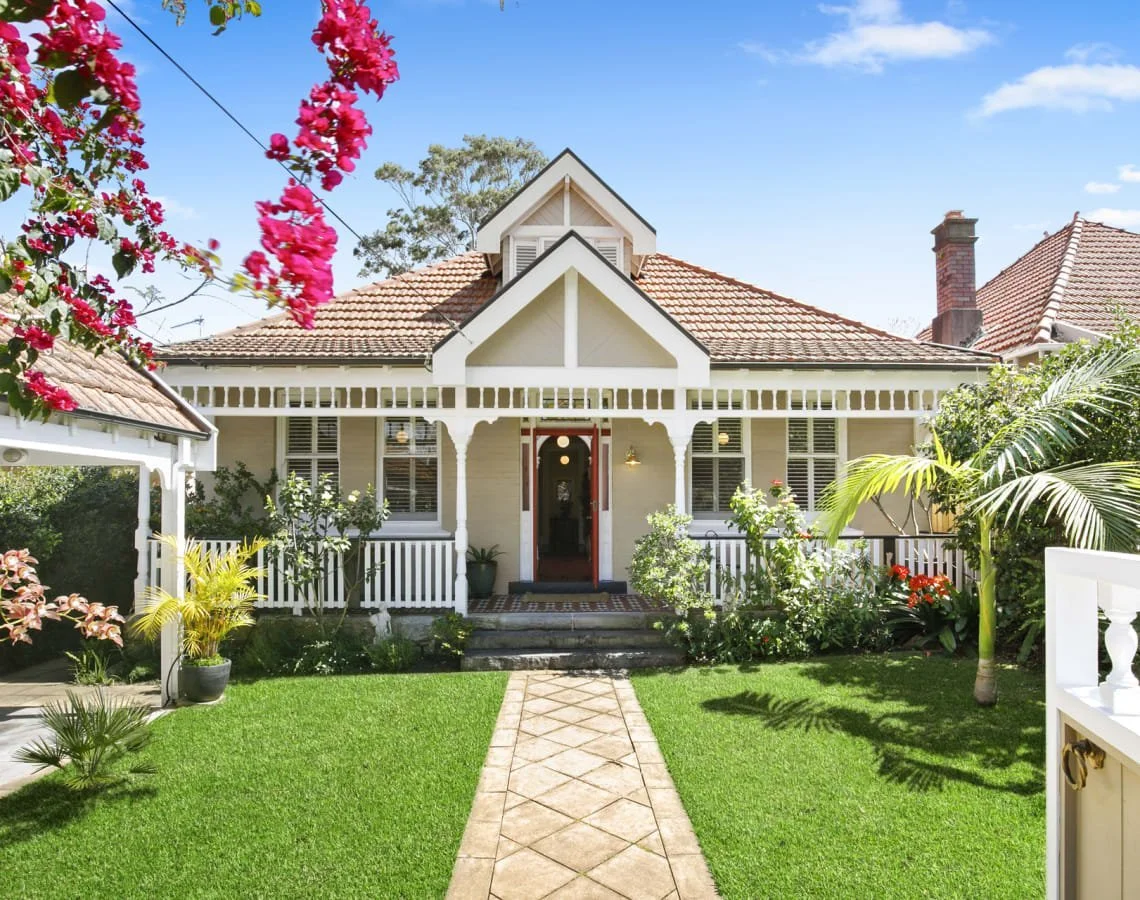 Traditional Mosman home with a verandah framed by vibrant flowers and a manicured lawn