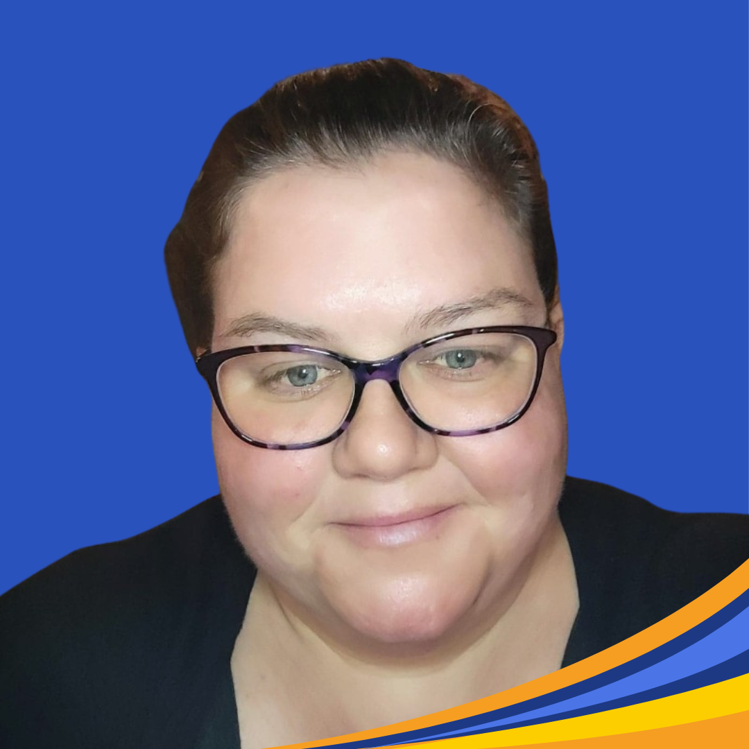 smiling woman with dark hair pulled back and wearing black glasses