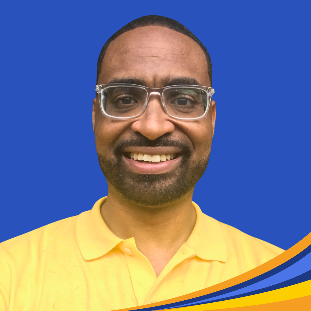 smiling man with yellow shirt and glasses