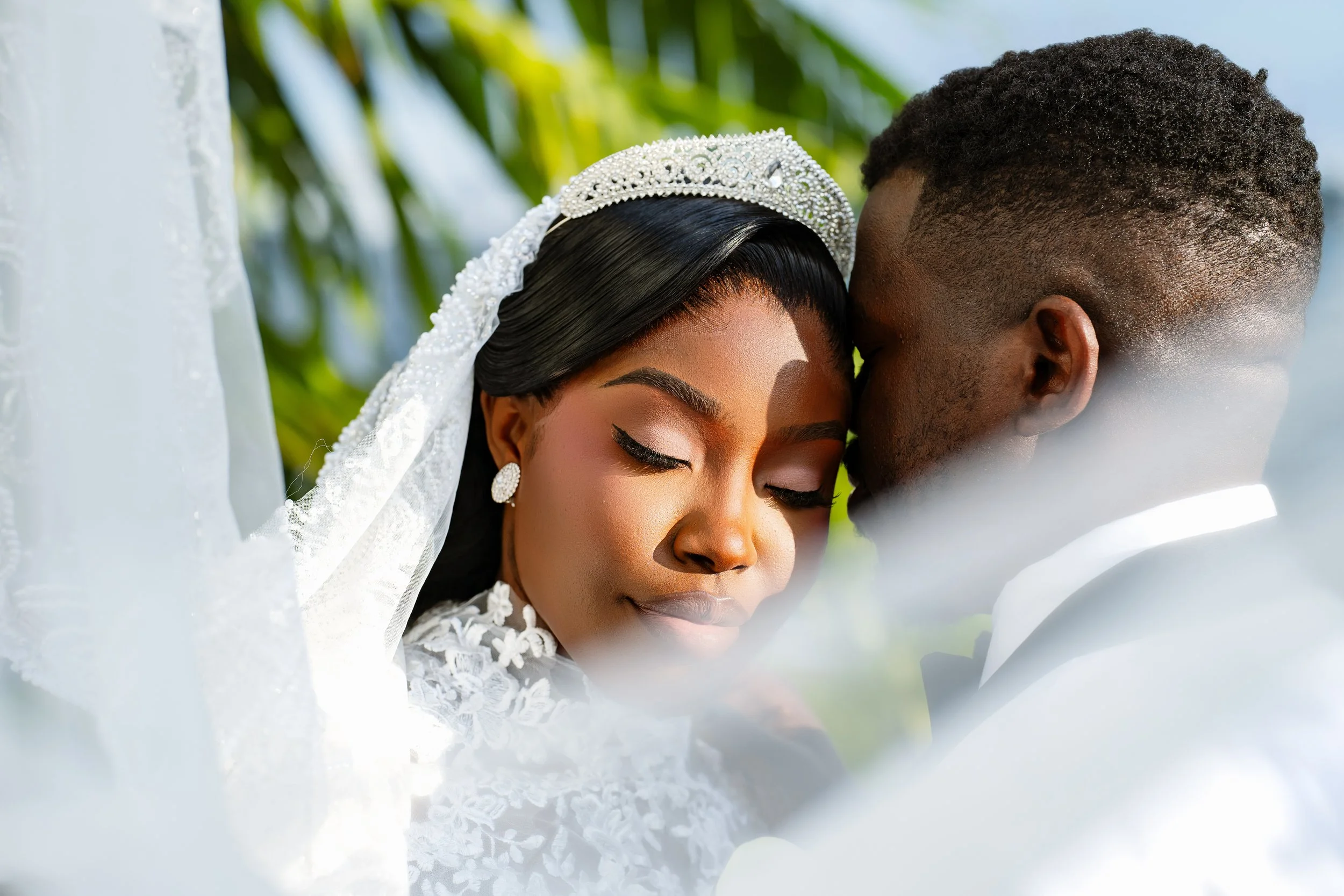 Close-up of a couple holding hands, with the woman in a white wedding dress and the man in a black tuxedo, during their wedding ceremony.