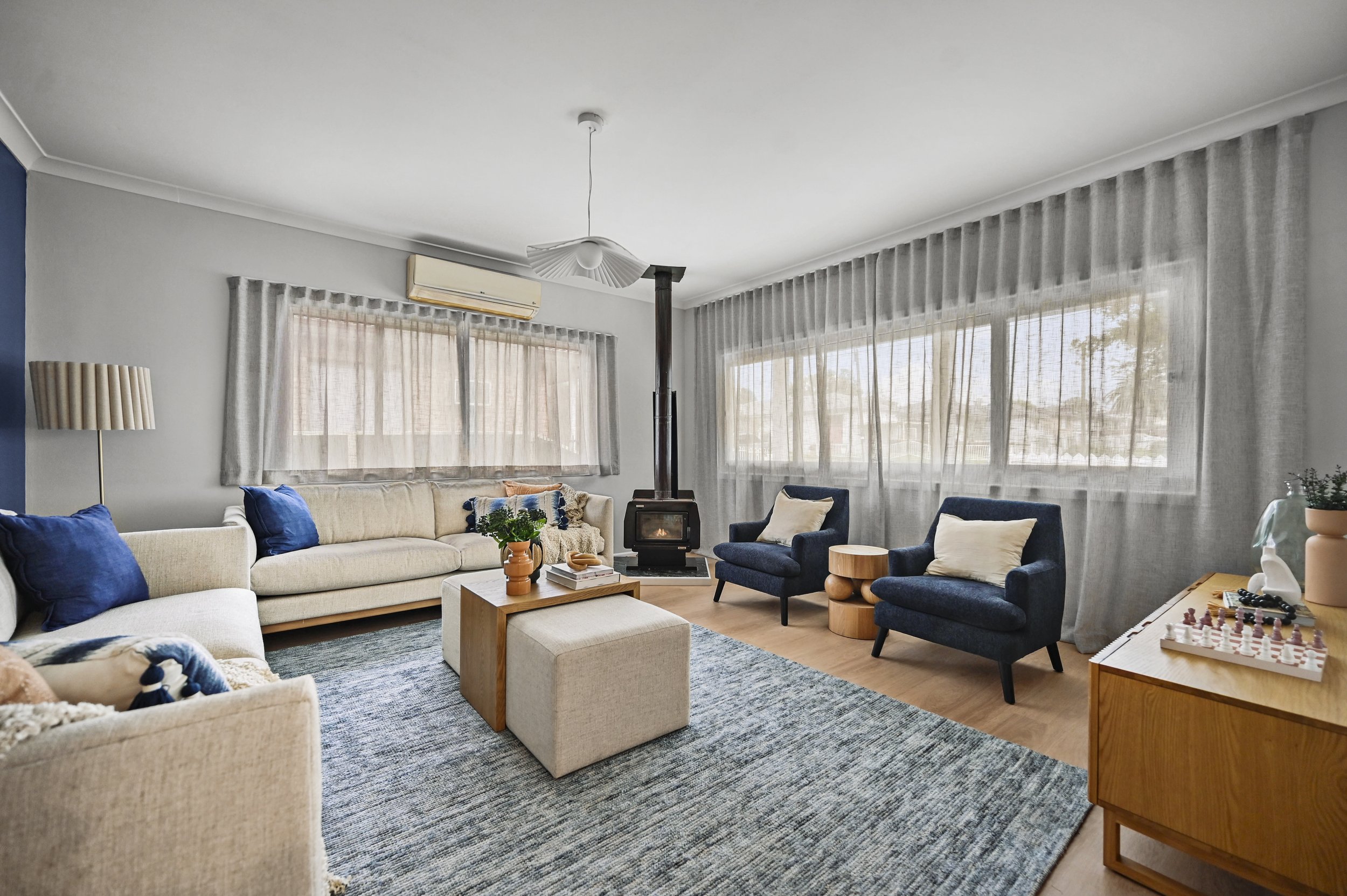Living room, after: After: Light, edited living room with pale timber flooring, layered lighting and soft neutrals. (Copy)