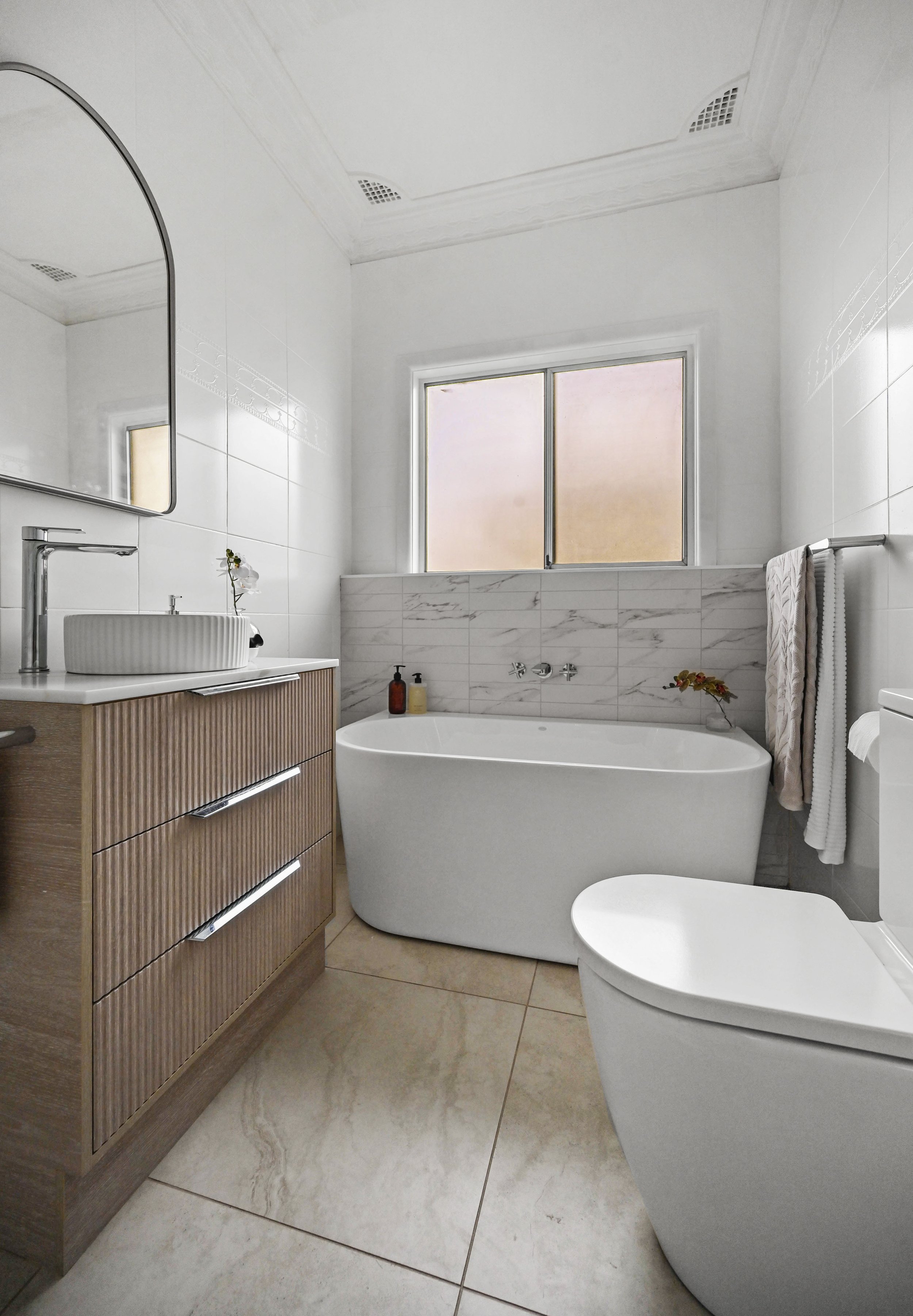 Bathroom After: Refreshed bathroom with resurfaced walls, Cava Borghini tiles, freestanding bath and arch mirror. (Copy)