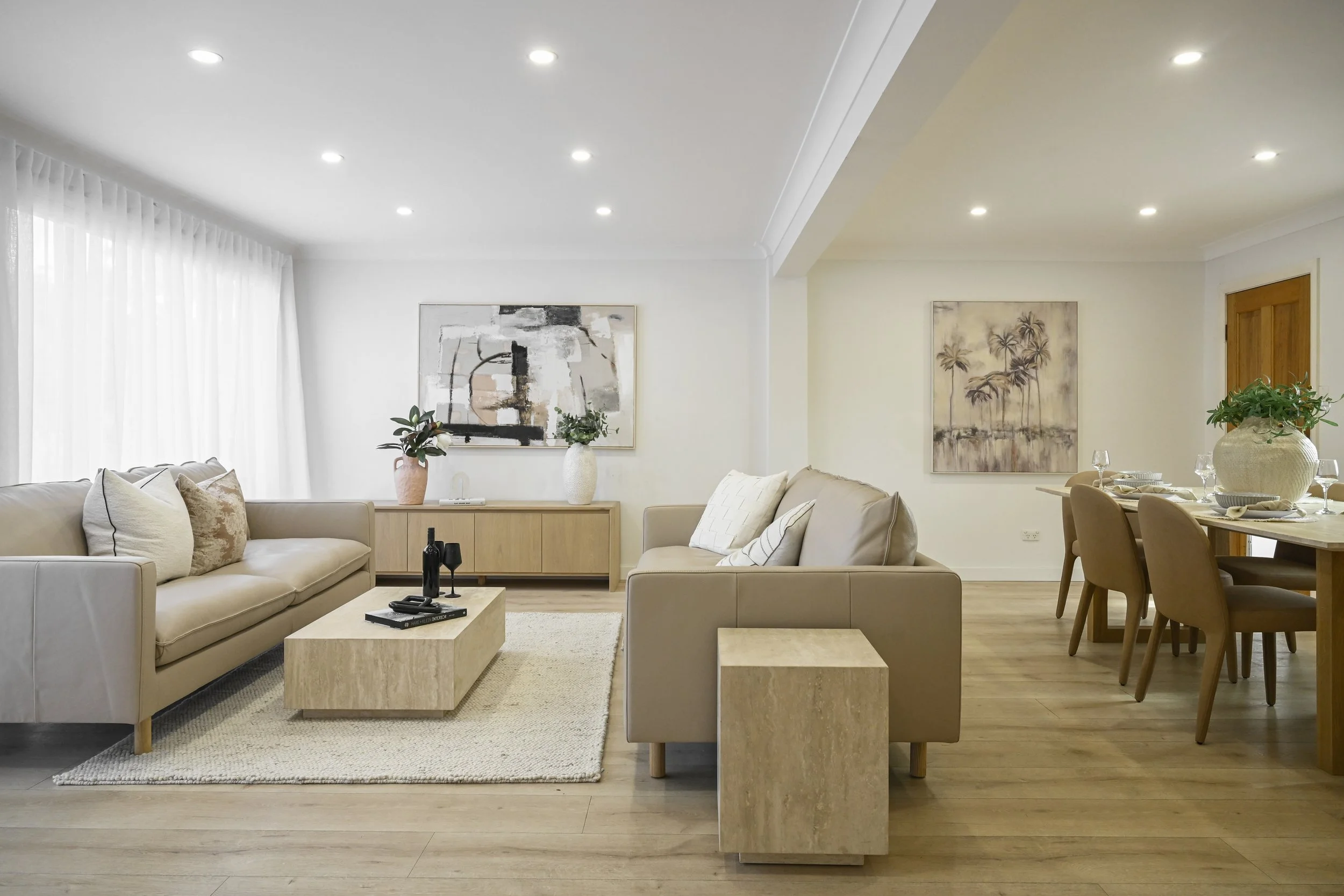 Calm living zone with new lighting, pale rug and cohesive furniture