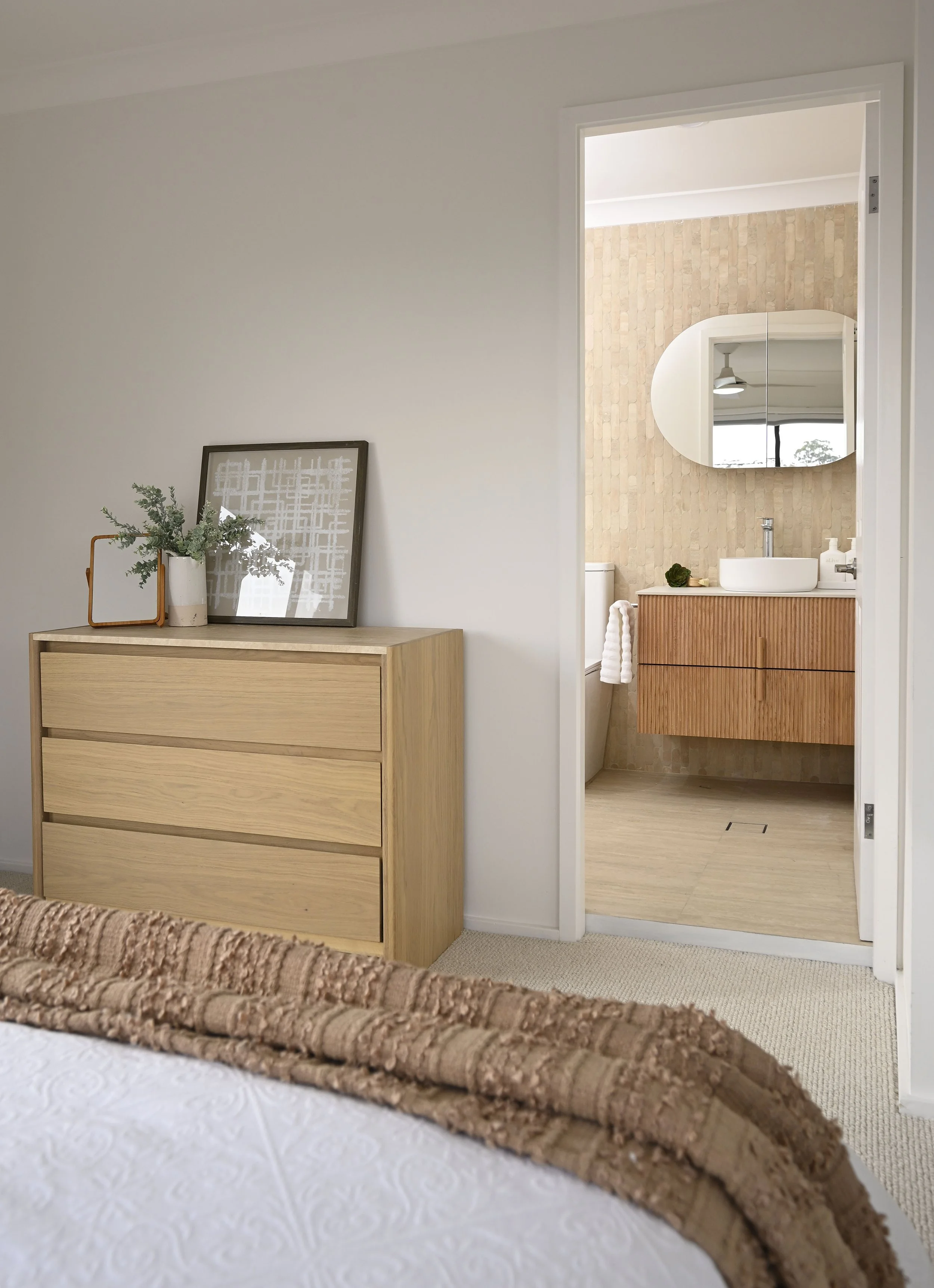 A timber tallboy in an updated bedroom