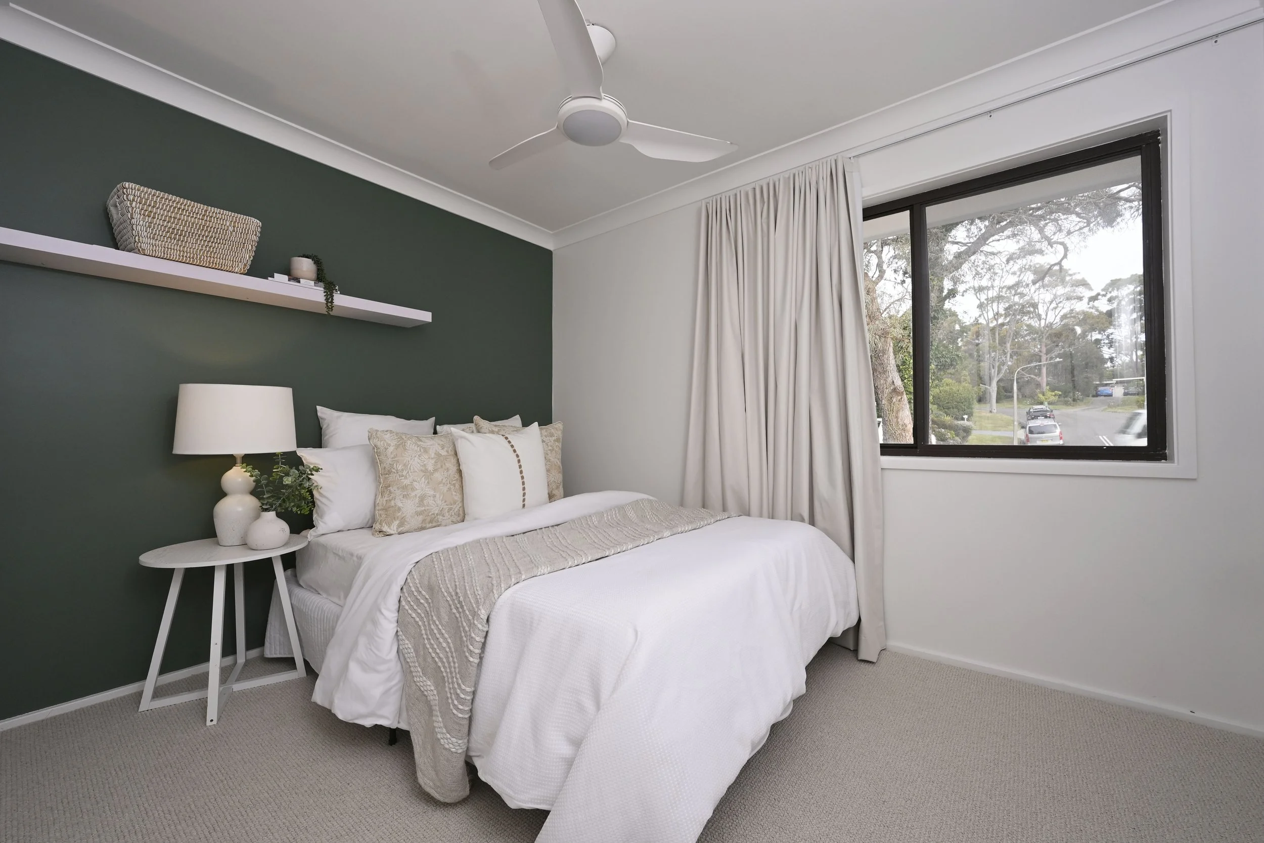 A dark feature wall in a bedroom with new carpet and fresh paint