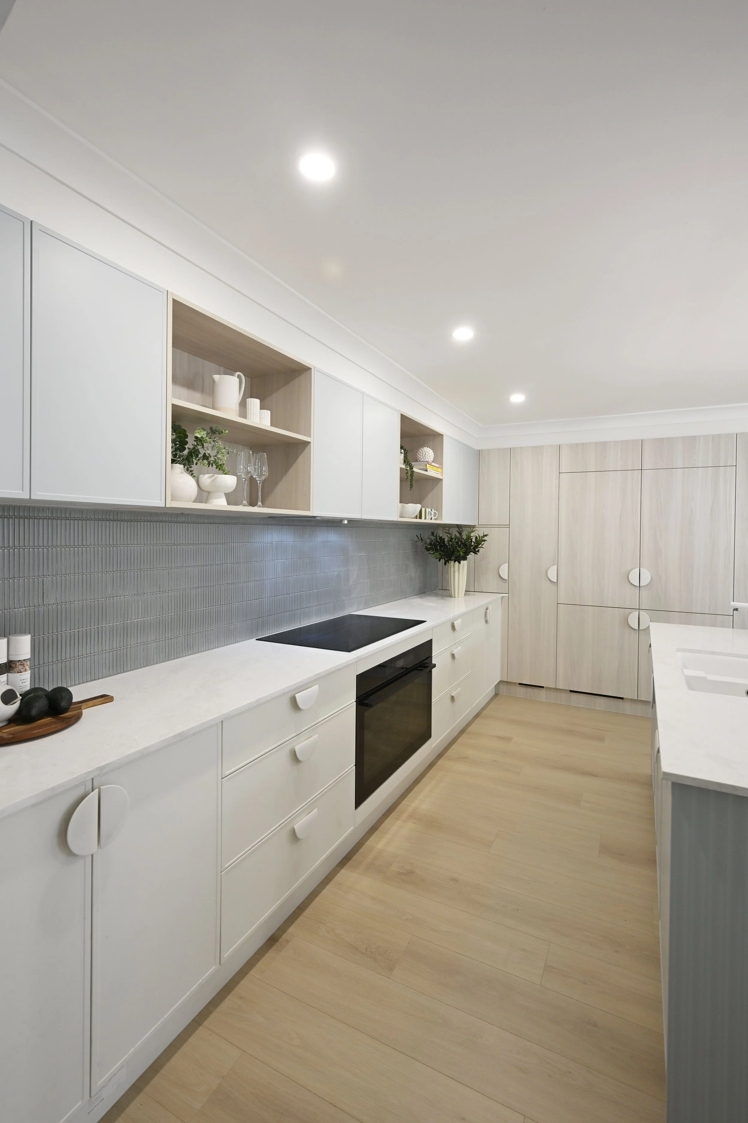 Open‑plan family kitchen with Caesarstone benchtops, soft cabinetry tones and integrated appliances