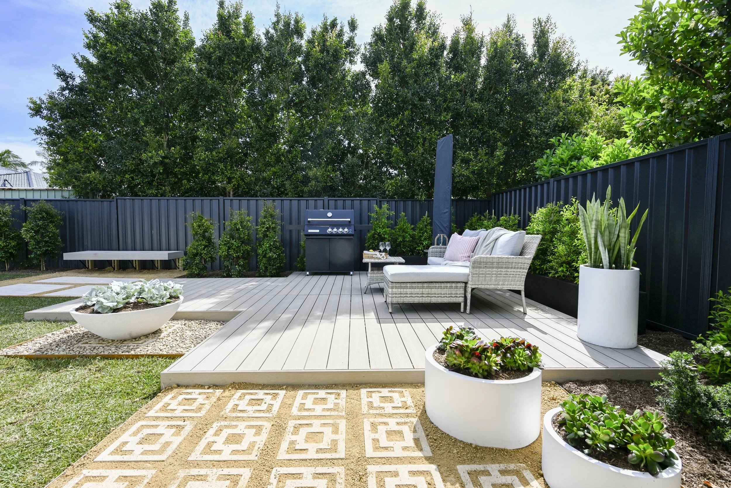 Inviting deck with seating, lush lawn and seamless indoor–outdoor connection