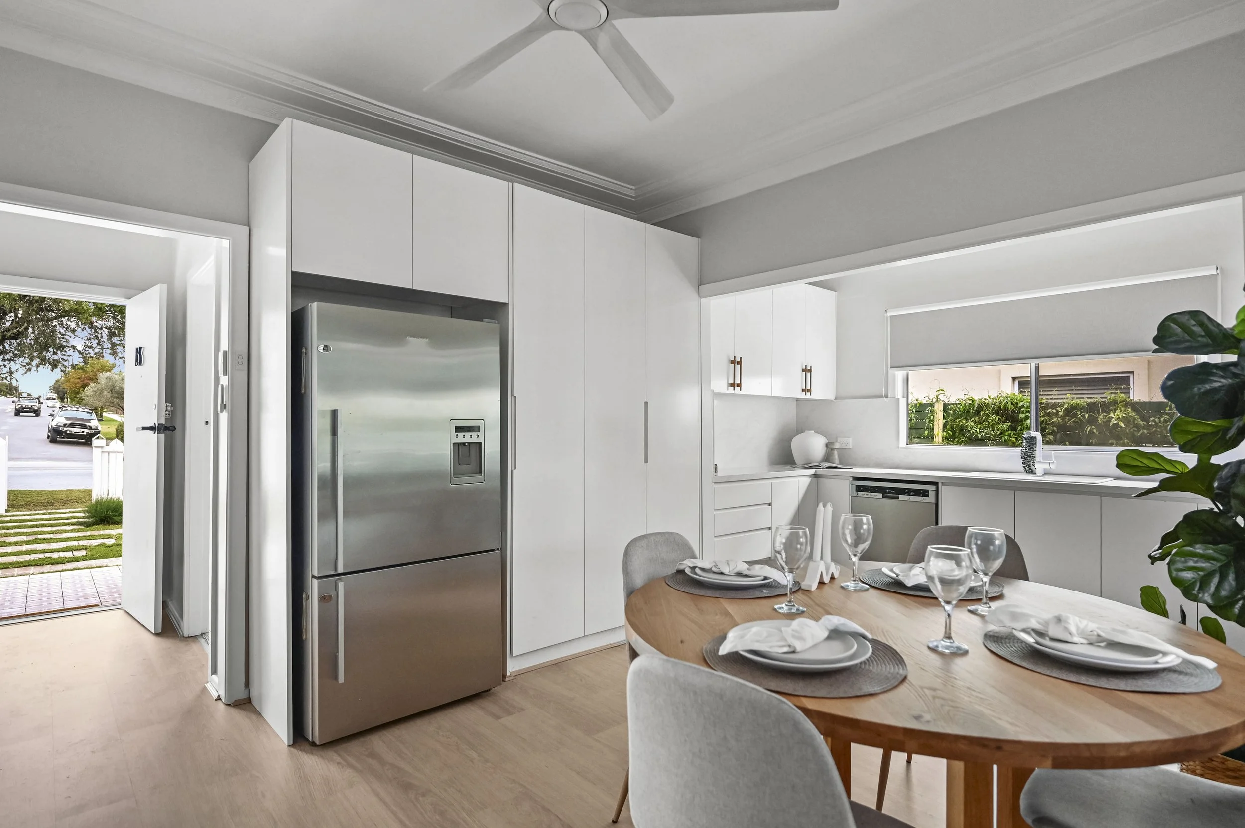 A modern kitchen with Caesarstone Glacier Flow wrap, timber‑tone handles and Blanco sink mixer