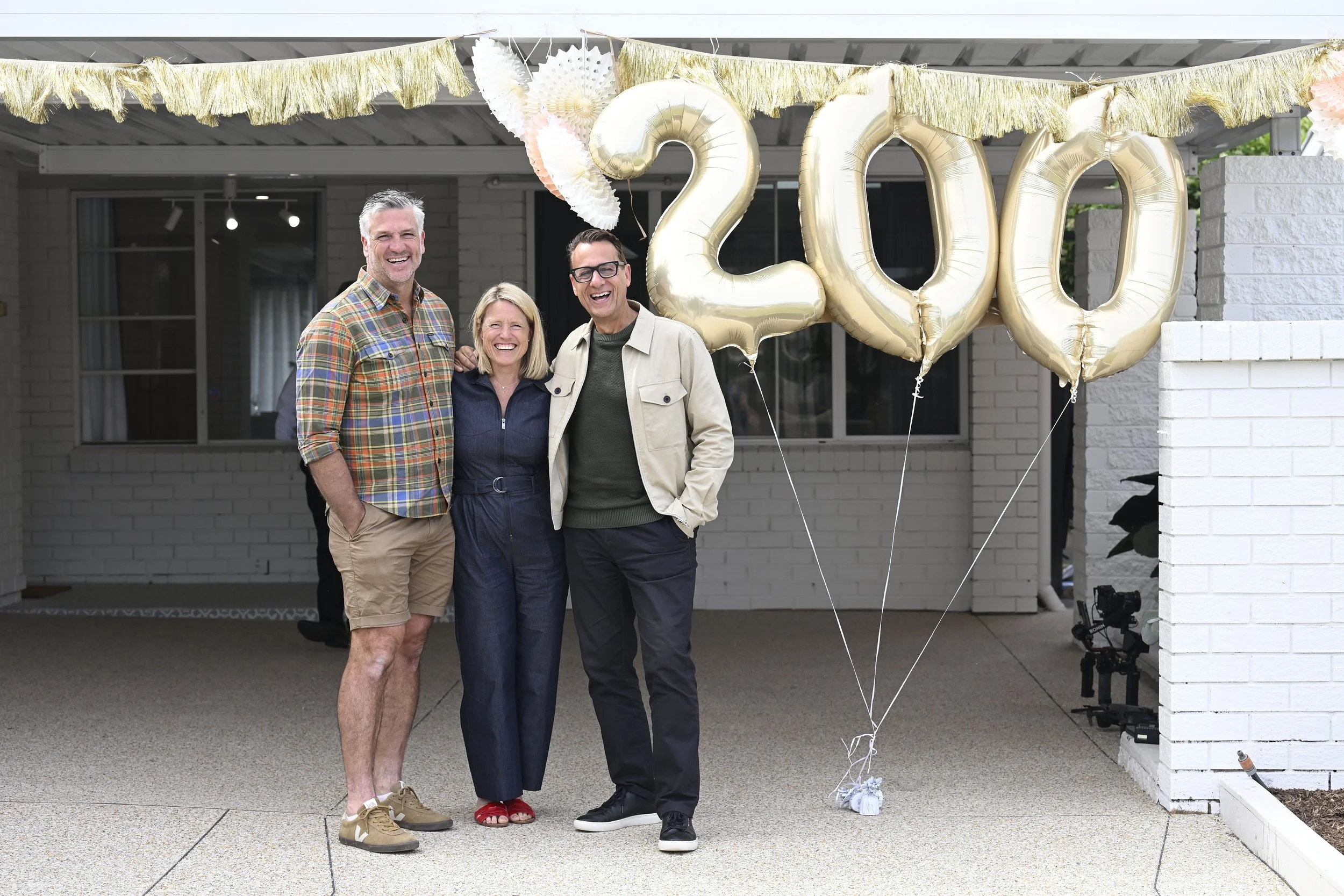 Dennis Scott, Wendy Moore and Andrew Winter stand next to giant foil balloons in the shape 200.