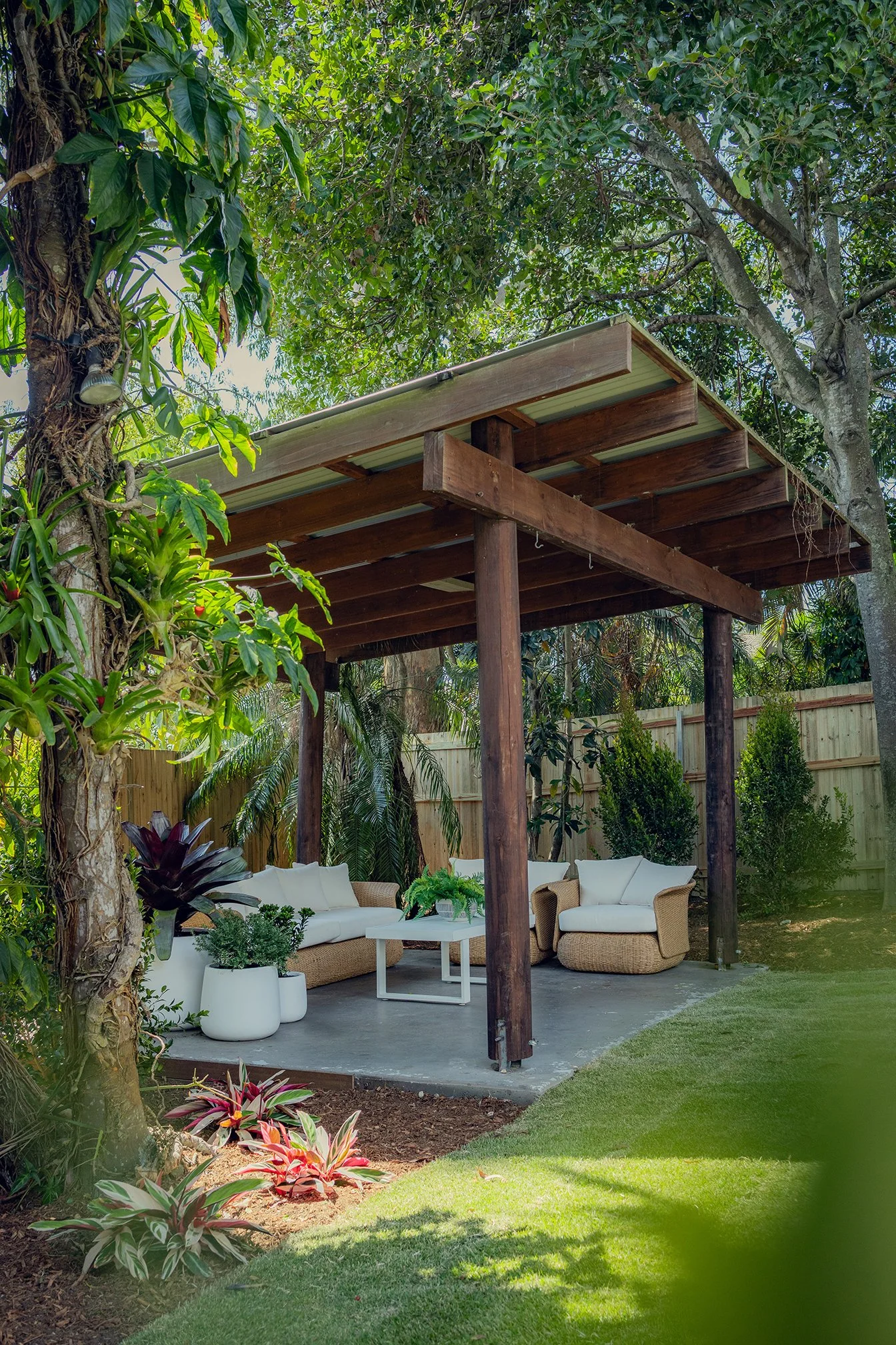 A tropical style garden with an entertaining area and timber pergola.
