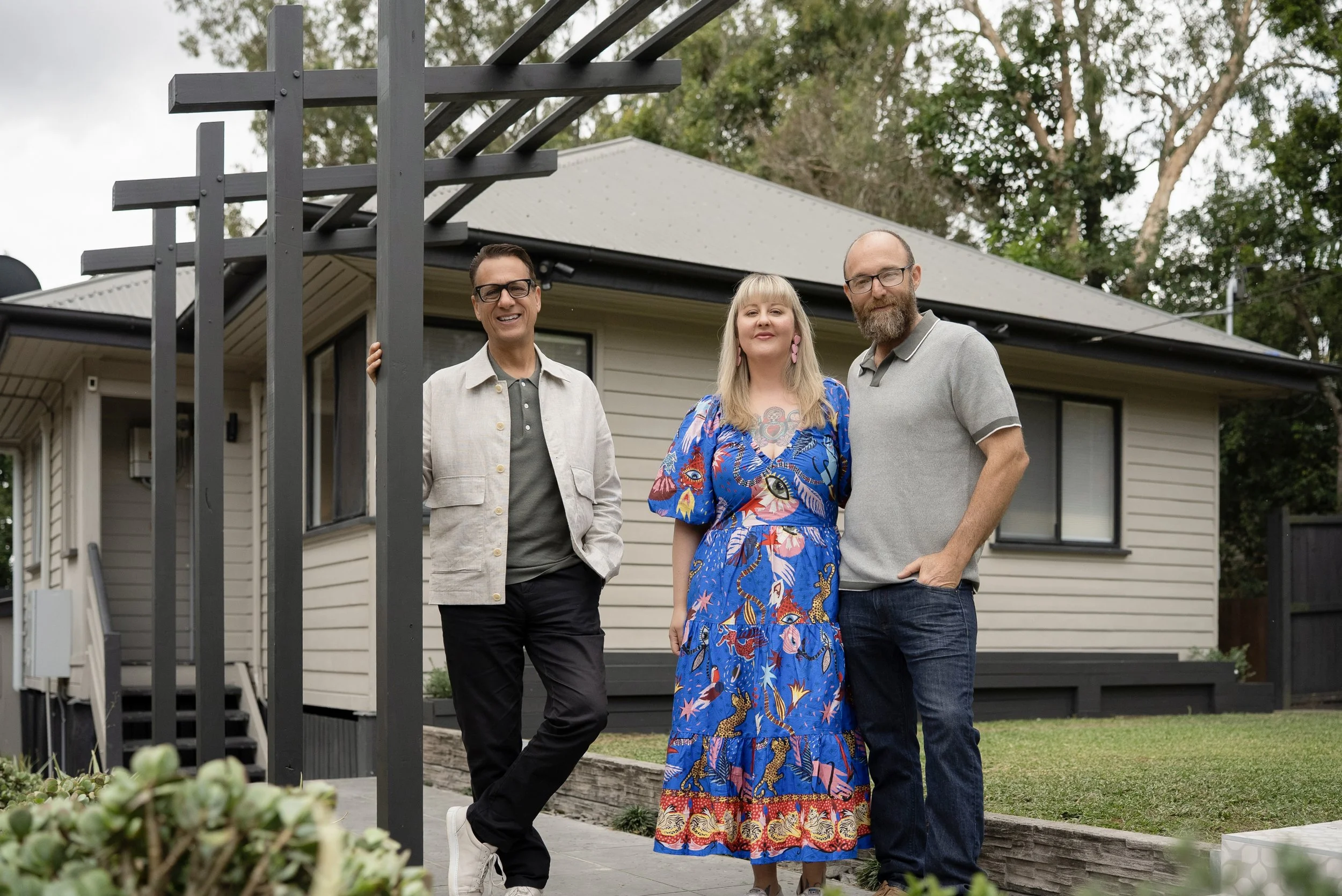 Andrew Winter, Belinda and Elton stand in front of the newly renovated house at Carina Heights.