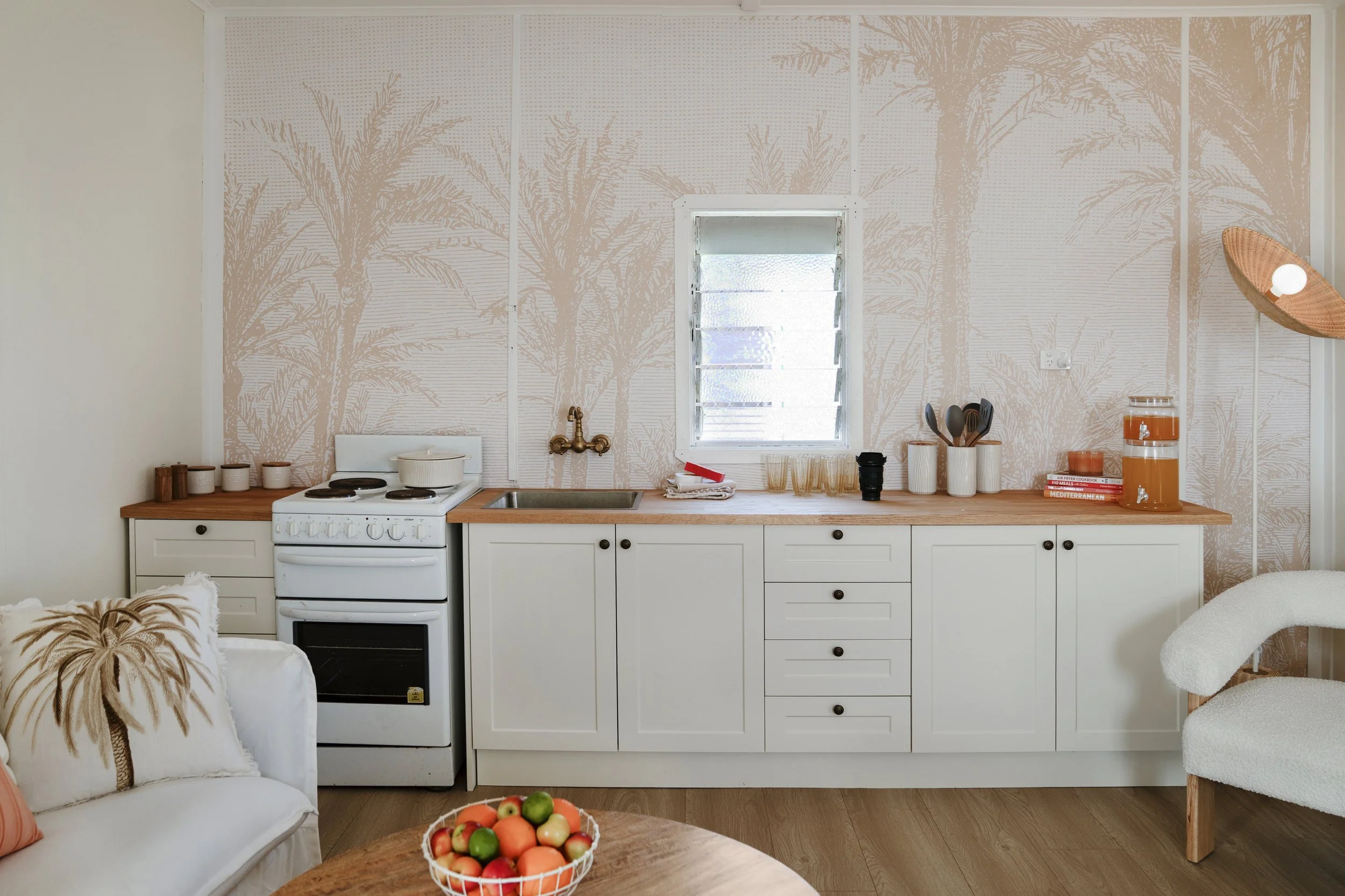 Renovated coastal kitchen with timber benchtop, new Antique Satin cabinetry, and brass handles