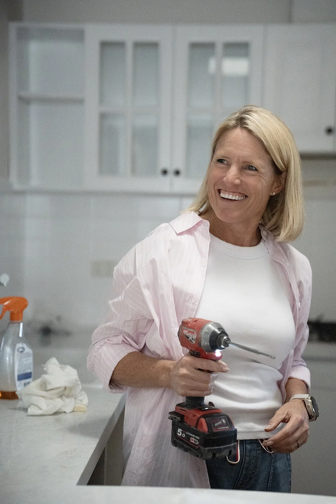 Wendy Moore smiling and holding an electric drill on Selling Houses Australia.