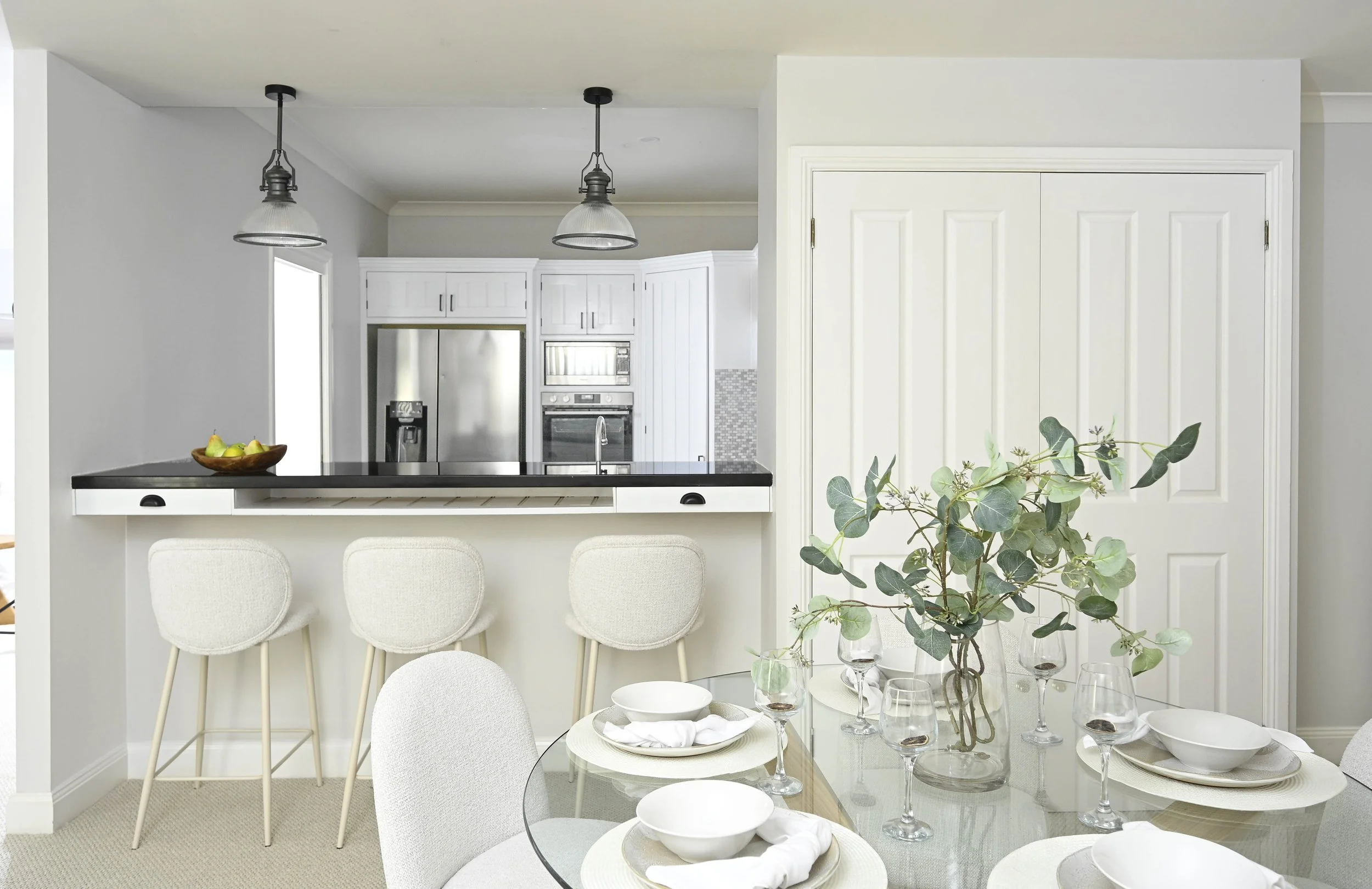 Neutral kitchen and dining area with uncluttered benchtops, open layout and natural light in Selling Houses Australia renovation.