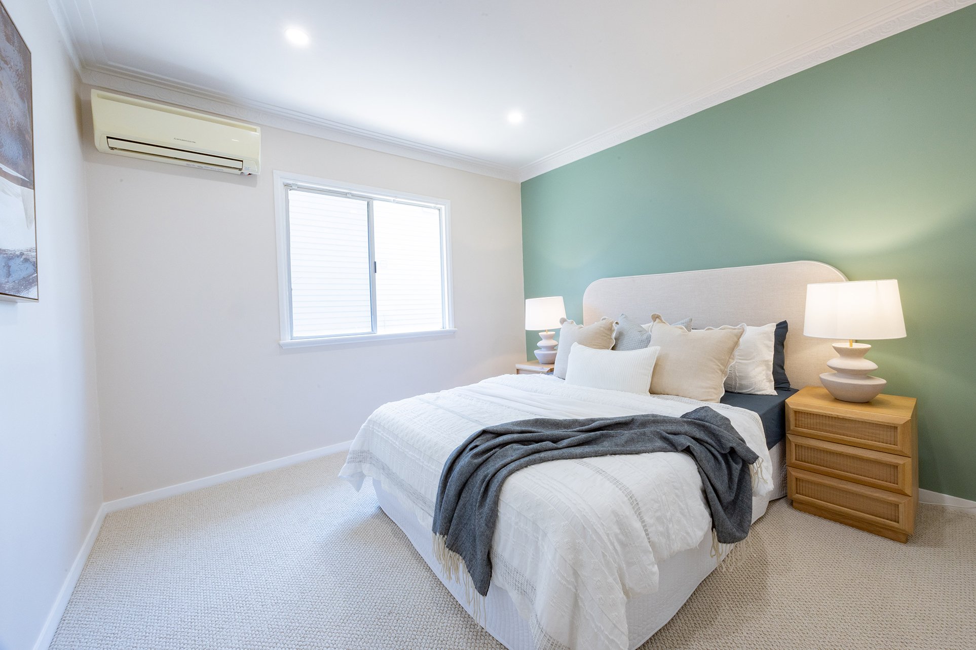 A calming bedroom with a green feature wall.