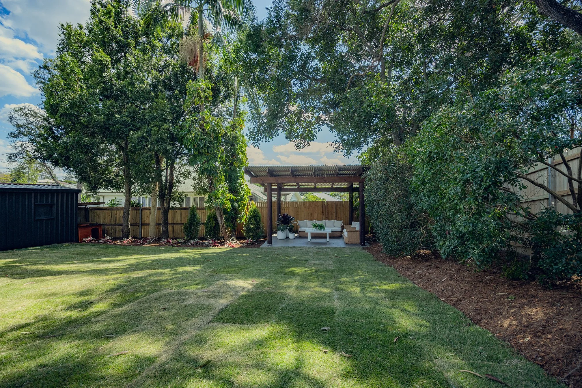 Fresh green lawn and neat garden beds in the backyard at Carina Heights.