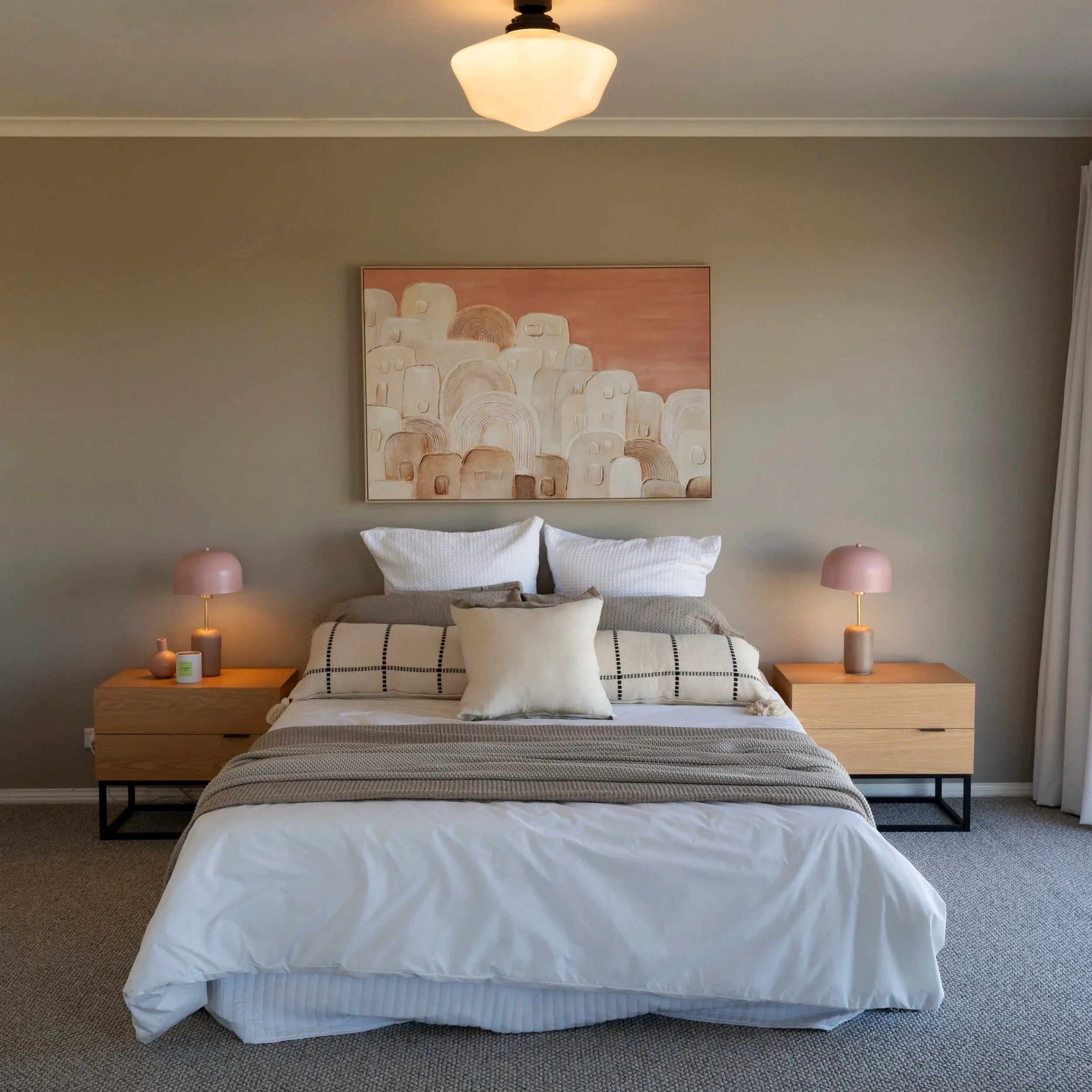 Luxurious master bedroom with soft neutral tones, large windows, bay seating and cohesive styling in Gisborne country home.