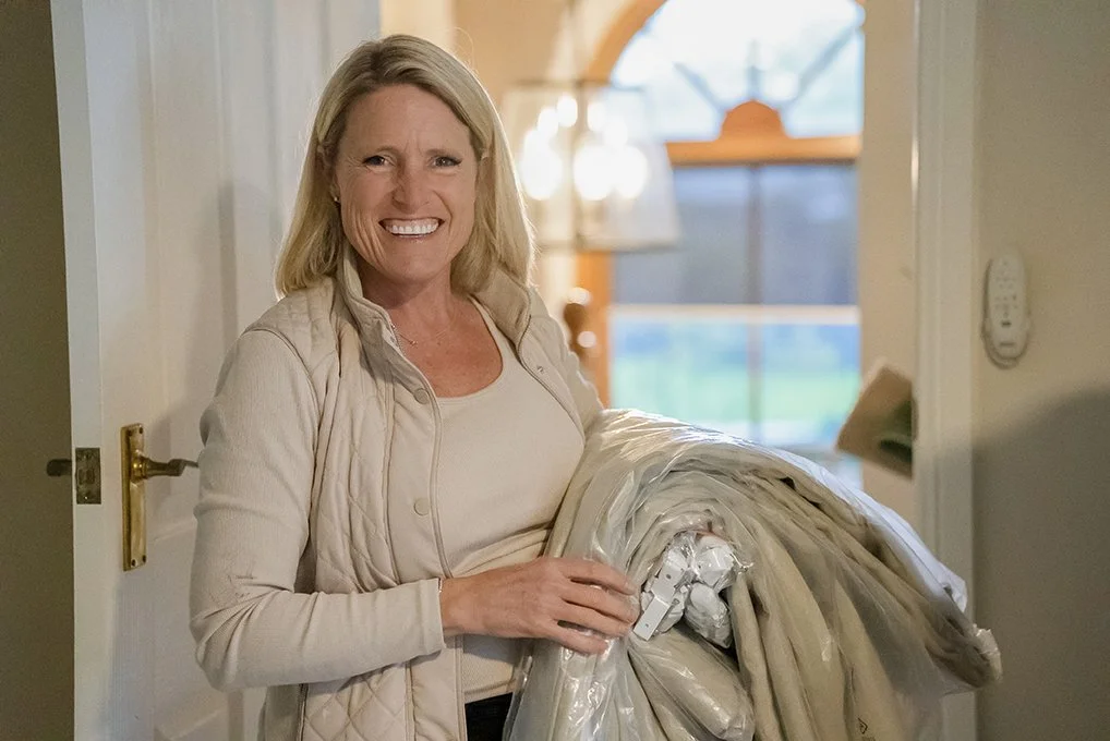 Host Wendy Moore from Selling Houses Australia smiling and carrying fabric at the Oatlands renovation.