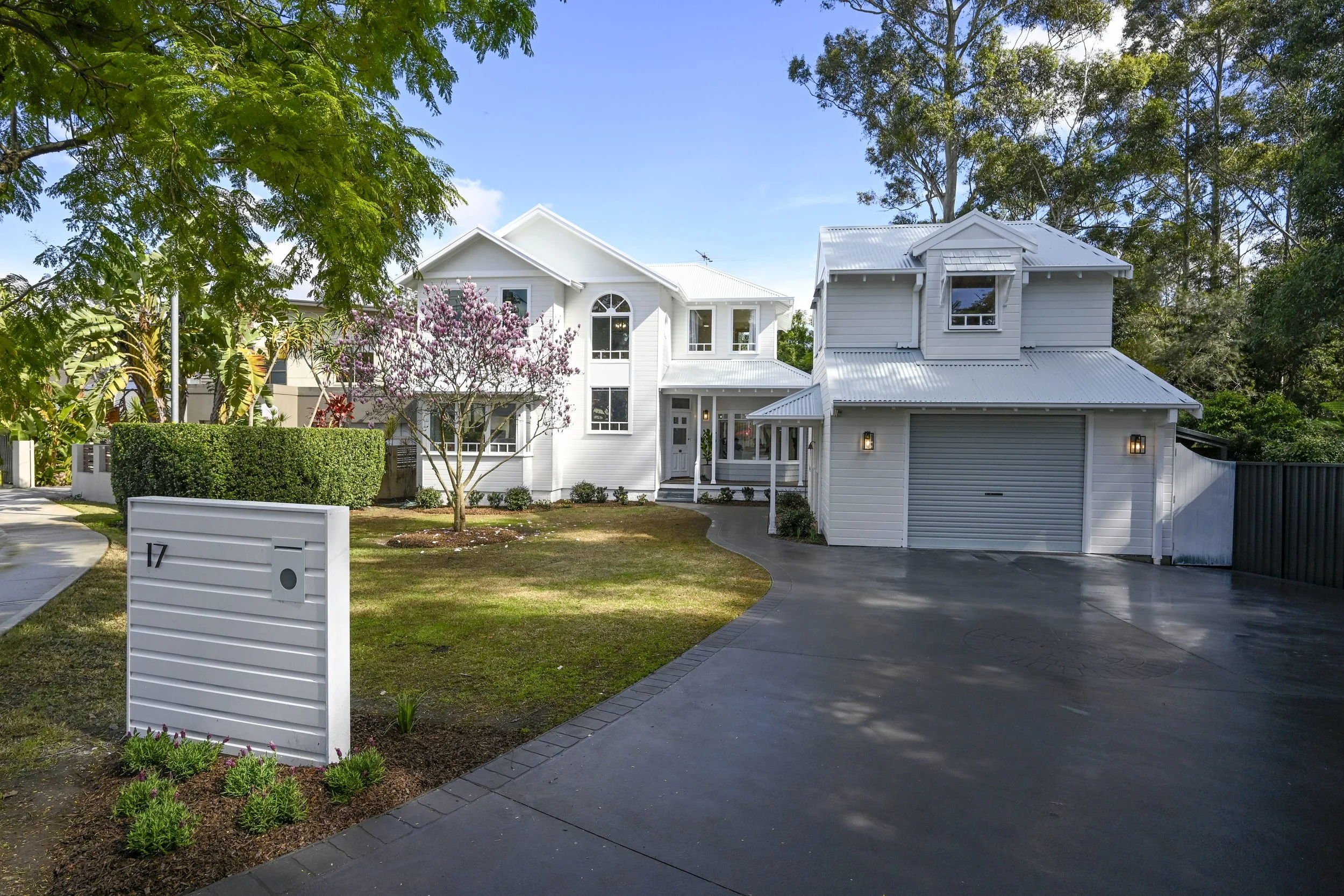 Renovated family home in Oaklands NSW with white exterior, classic front veranda, manicured garden and neutral coastal colour palette.