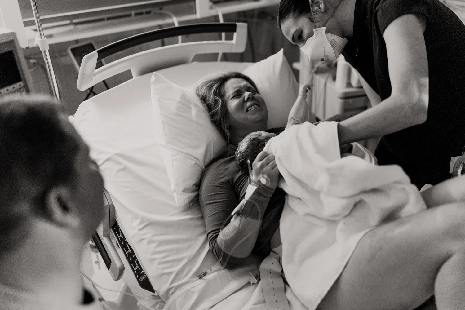 mother in labour in hospital suite with husband holding her hand