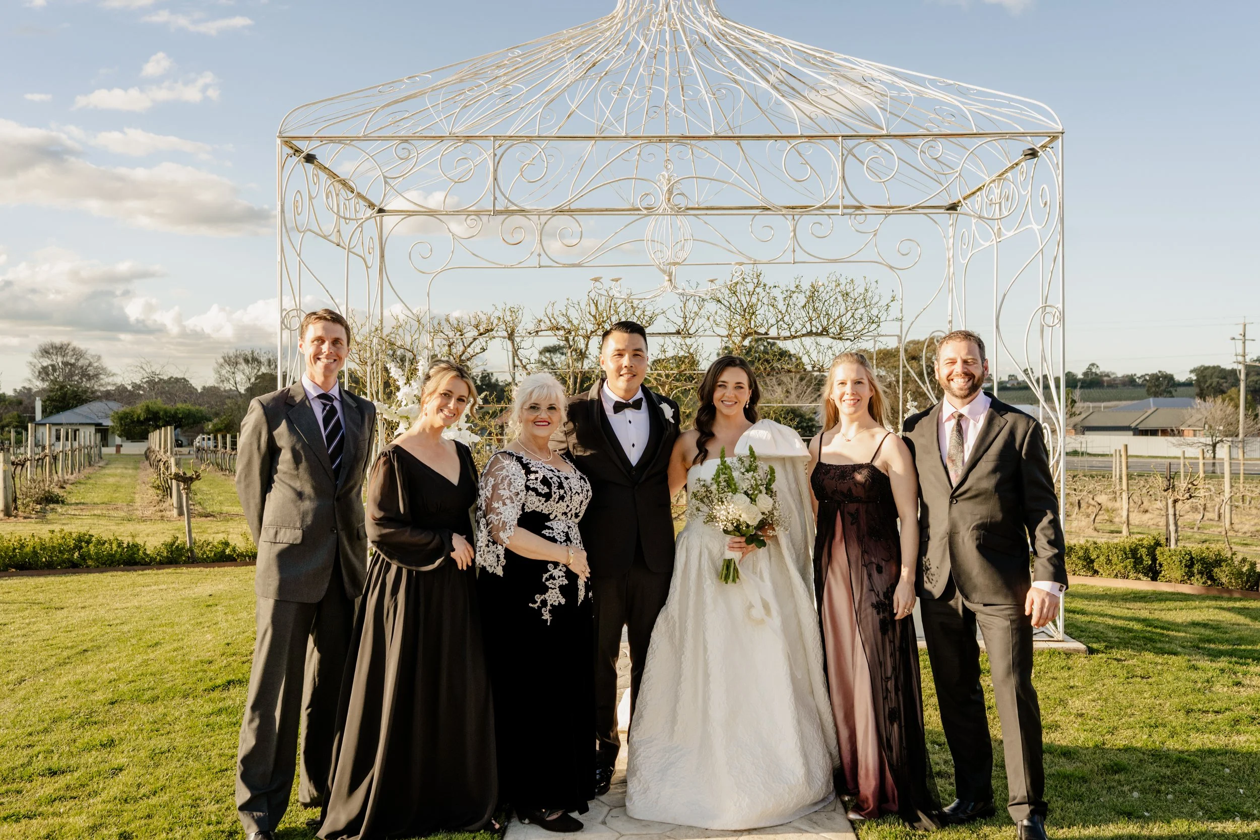Bride and groom family photo outside