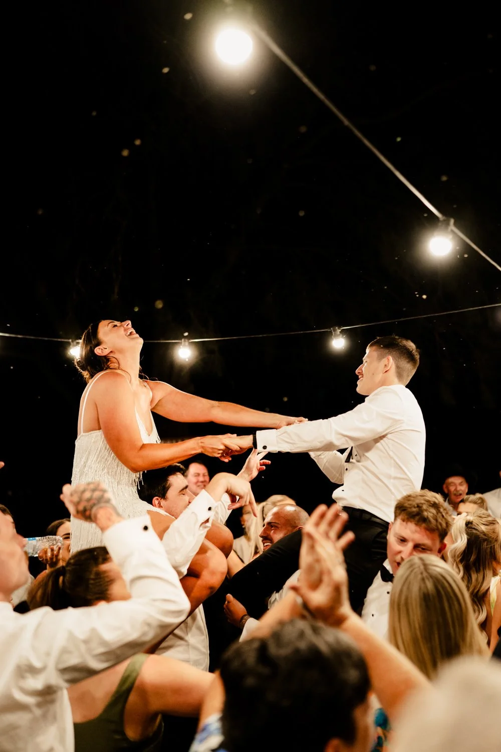 couple on the dance floor on people shoulders