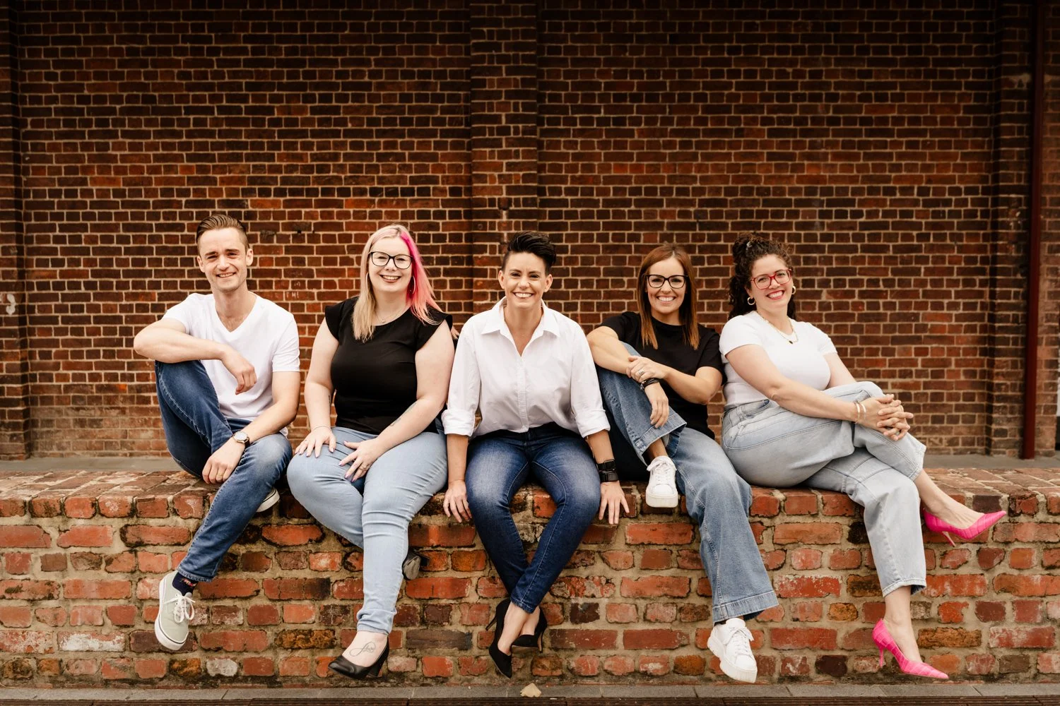 accounting team sits together on the brick wall