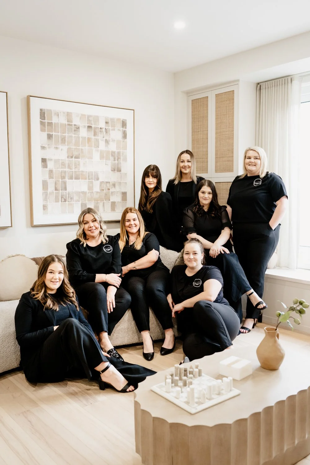 Real Estate team sit together look and smile at the camera