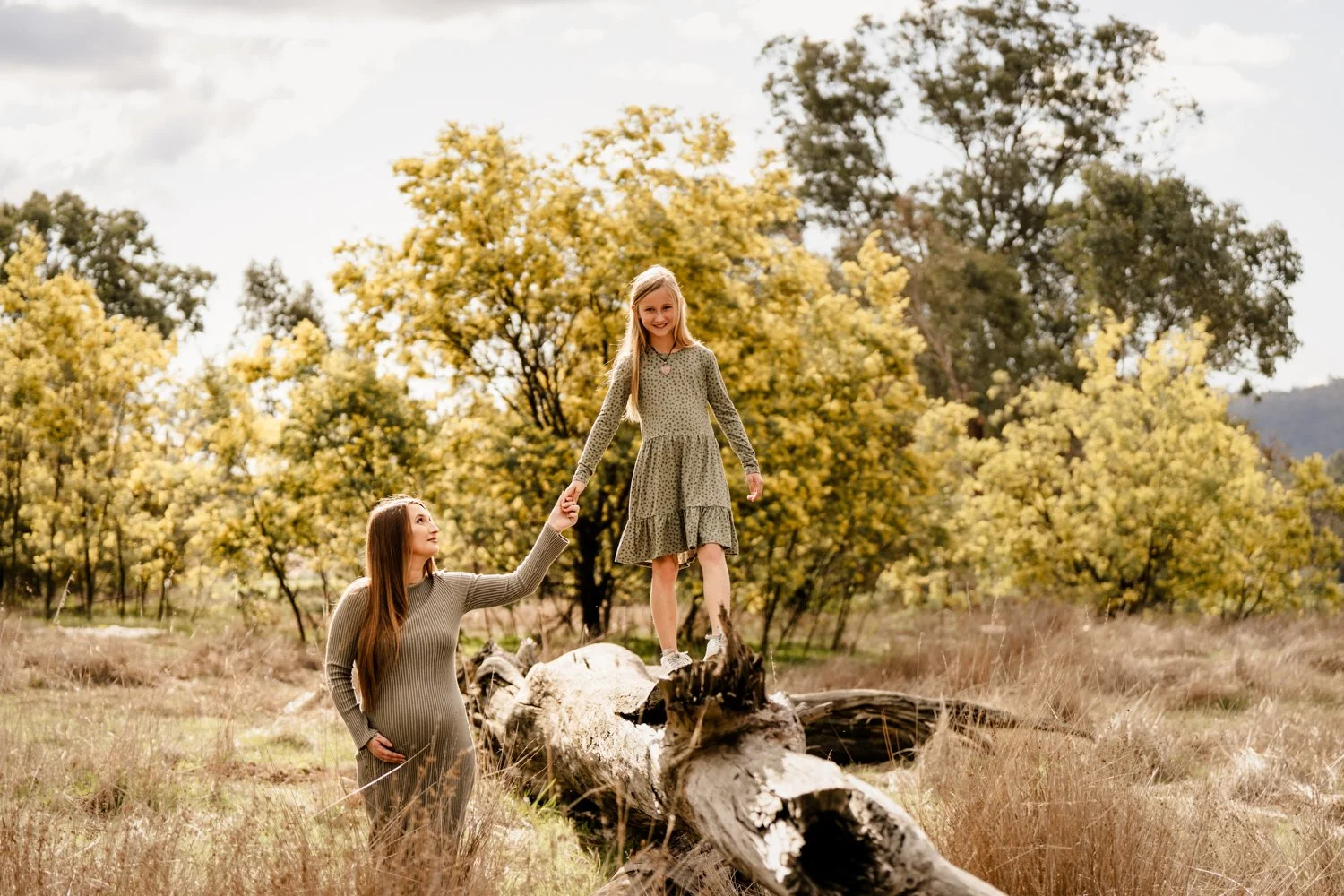 extended family stands together at sunset by the lake