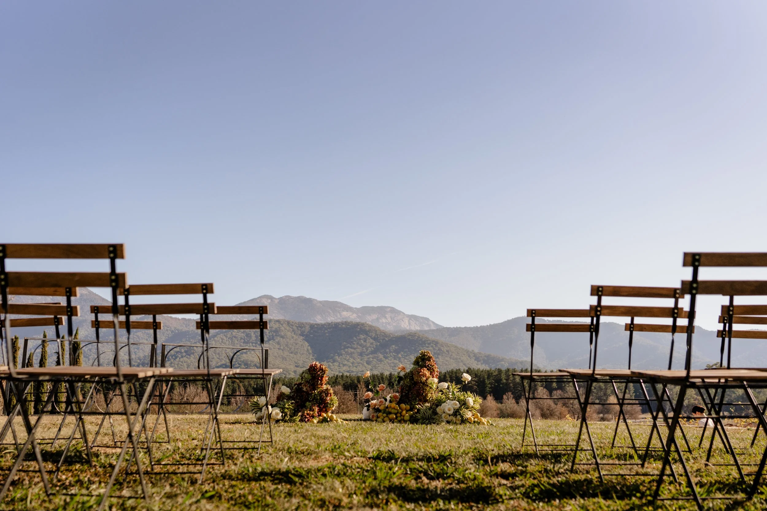 Ceremony setting with brown bistro chairs and a mountain backdrop