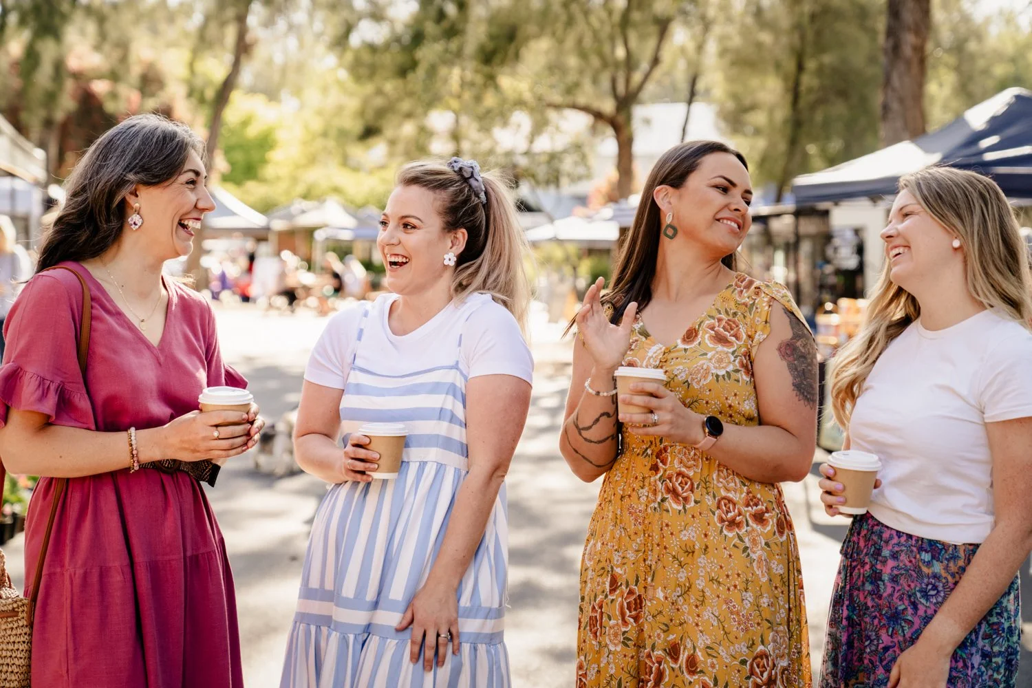 girls laugh together dirnking coffee